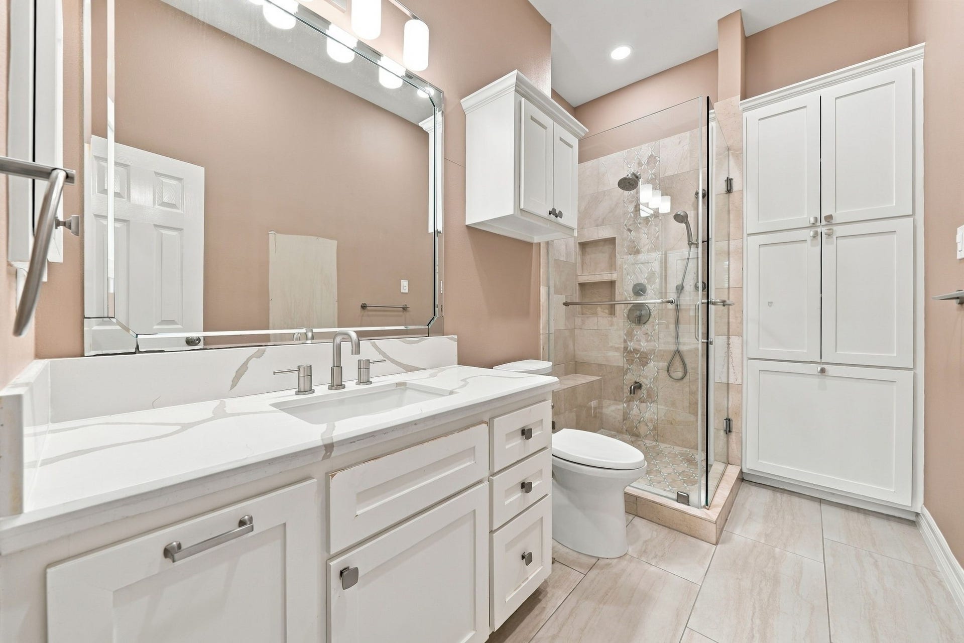 7610 Northwoods Drive, Sugar Land, TX 77479 Thoughtfully designed for privacy, Bedroom 4 features its own bath with a glass-enclosed shower and excellent built-in storage.