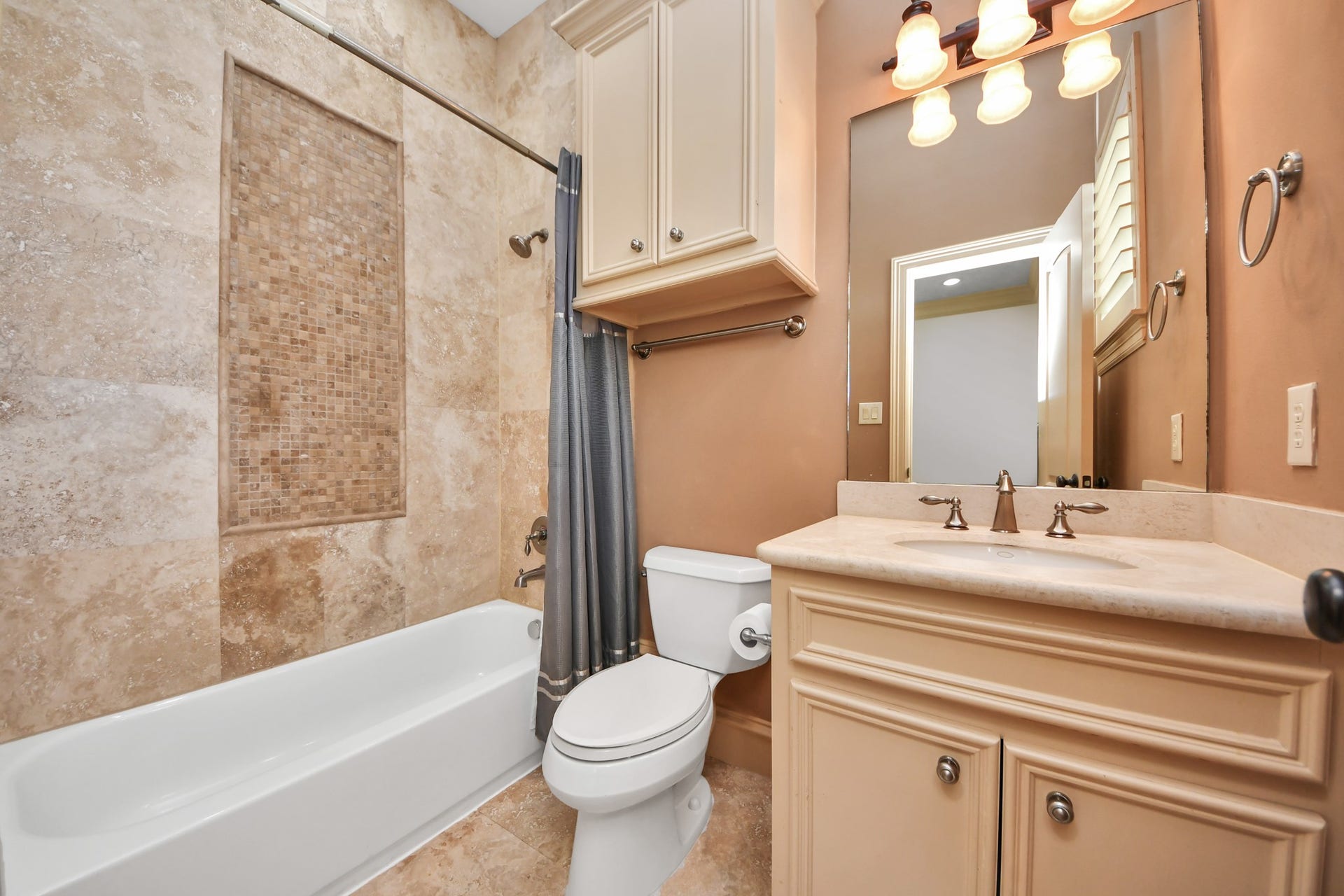 Spacious utility room featuring ample cabinetry and a durable speckled floor, perfect for storage and organization.
