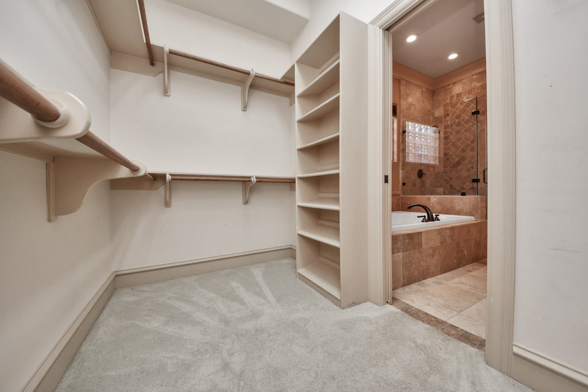Primary walk in closet with lots of space for organizing shoes, purses and etc.