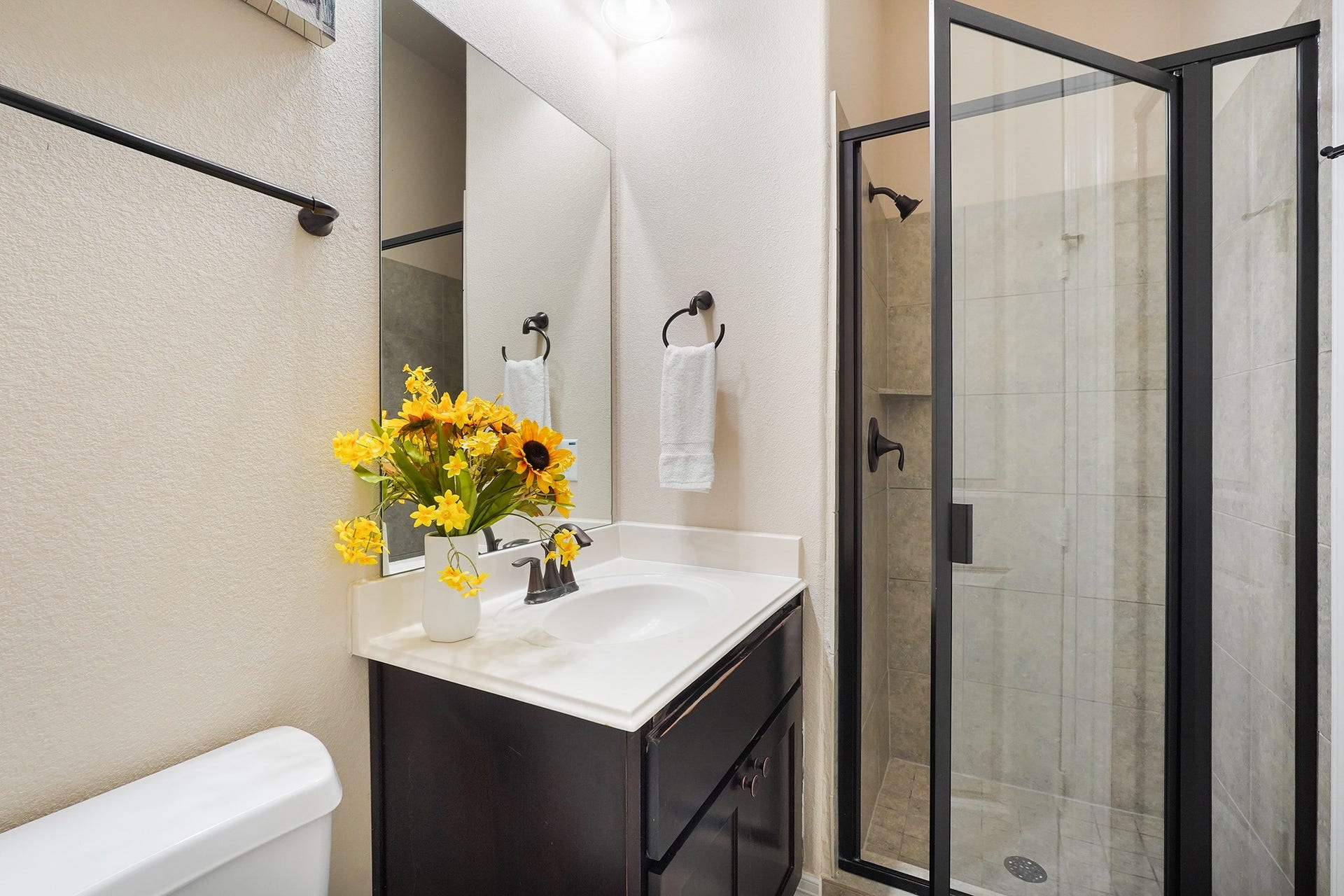 3102 Barrons Way, Sugar Land, TX 77479 FIRST Flr-2nd bedroom down: This bathroom features a modern glass-enclosed shower, and a sleek vanity with a white countertop. It has a neutral color palette and efficient use of space.