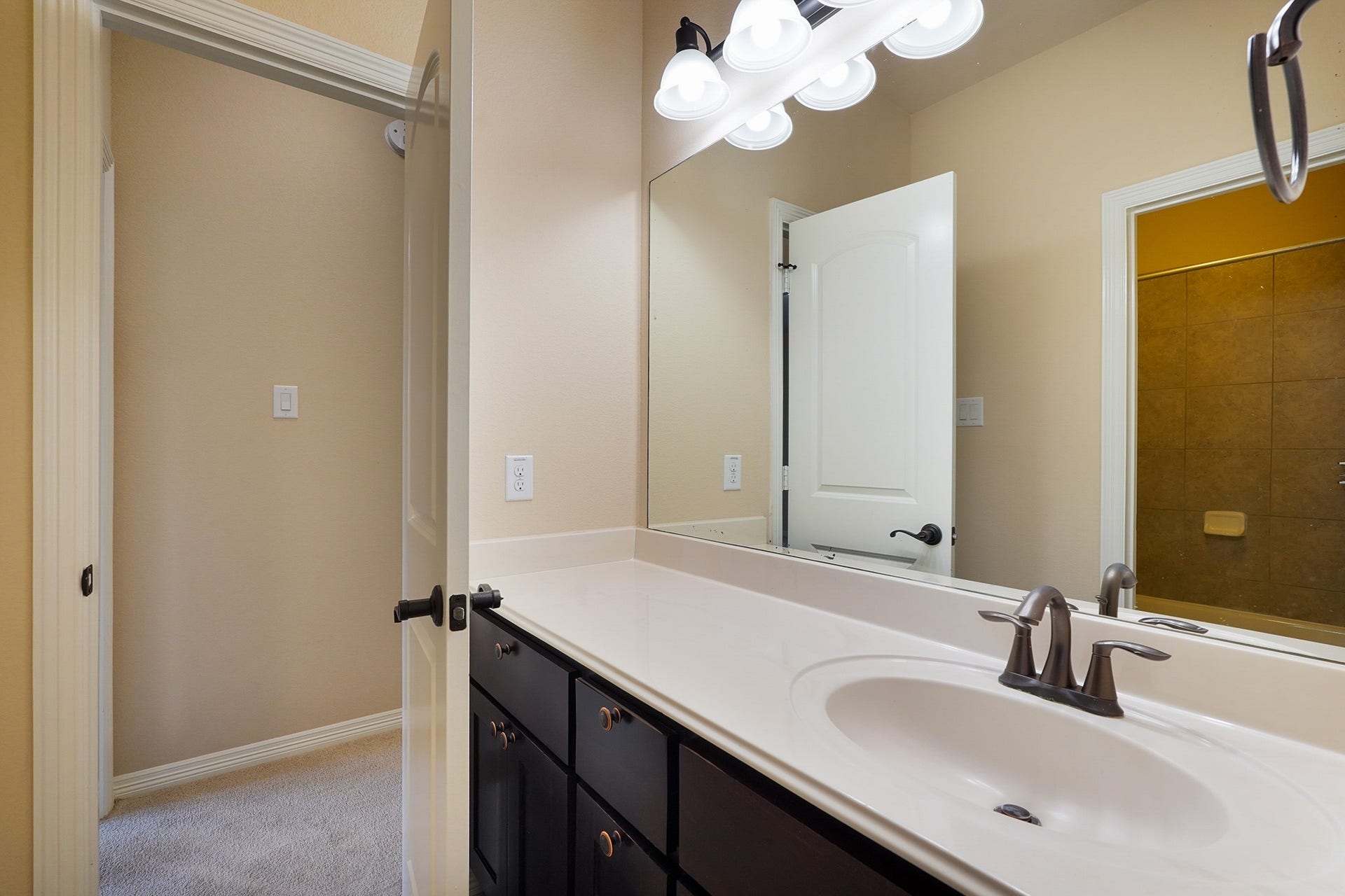 3102 Barrons Way, Sugar Land, TX 77479 SECOND Flr-Bath#3: Bright bathroom with a large mirror, modern fixtures, and ample counter space. It features a dark wood vanity and connects to a carpeted hallway.