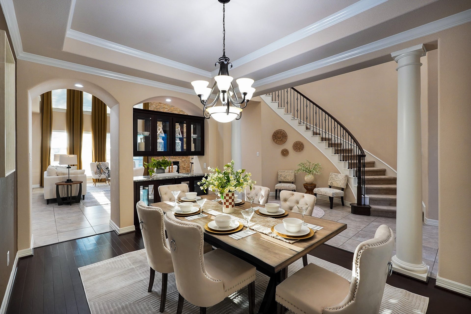 3102 Barrons Way, Sugar Land, TX 77479 This home features a grand, curved staircase with wrought iron railings, leading to an open, airy foyer. The space is adorned with neutral tones and tiled flooring.