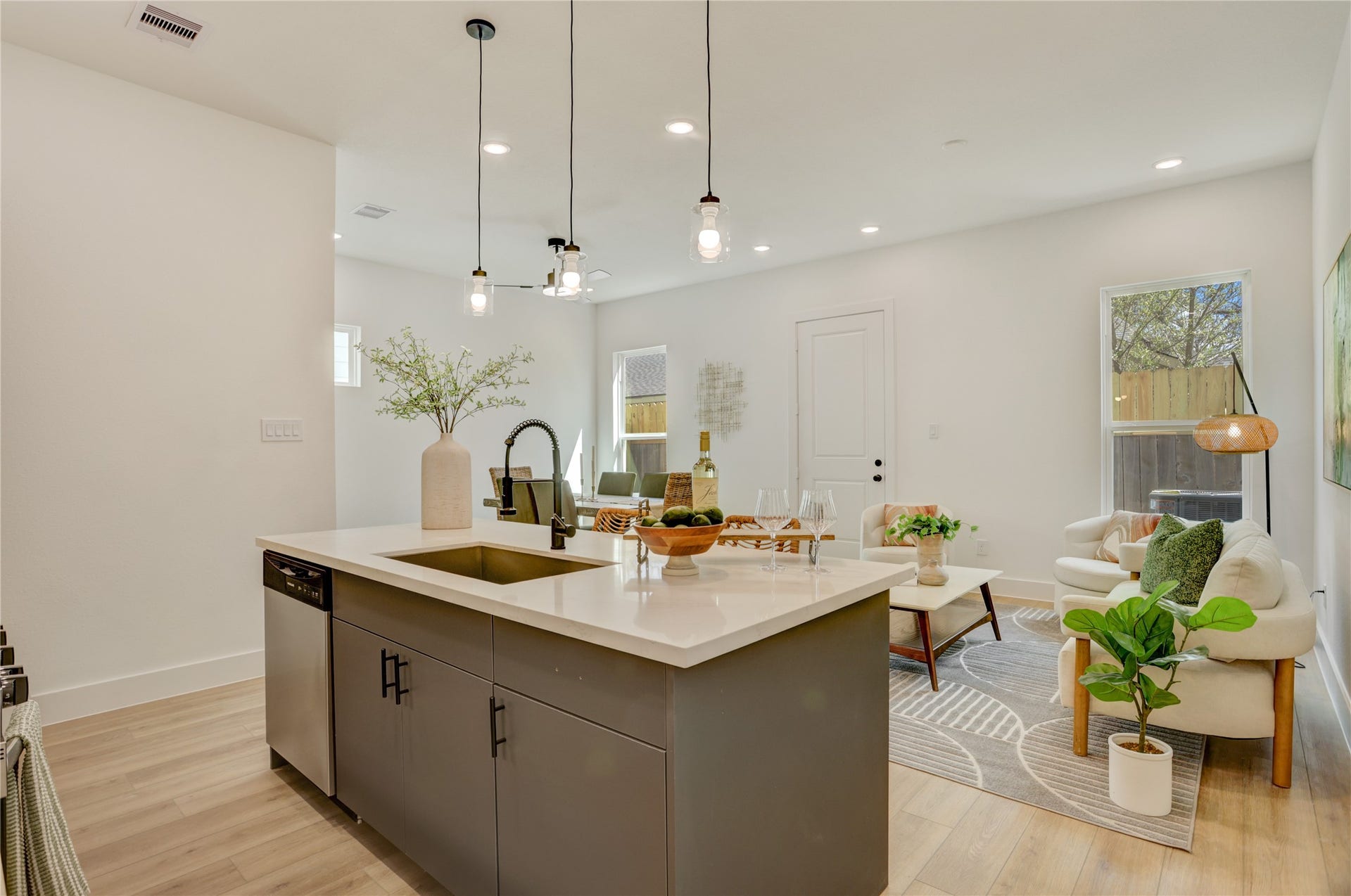 9610 Burden Street, Houston, TX 77093 The kitchen island has a stainless steel undermount Kohler sink with retractable faucet and drip accessories, and custom pendant lights.