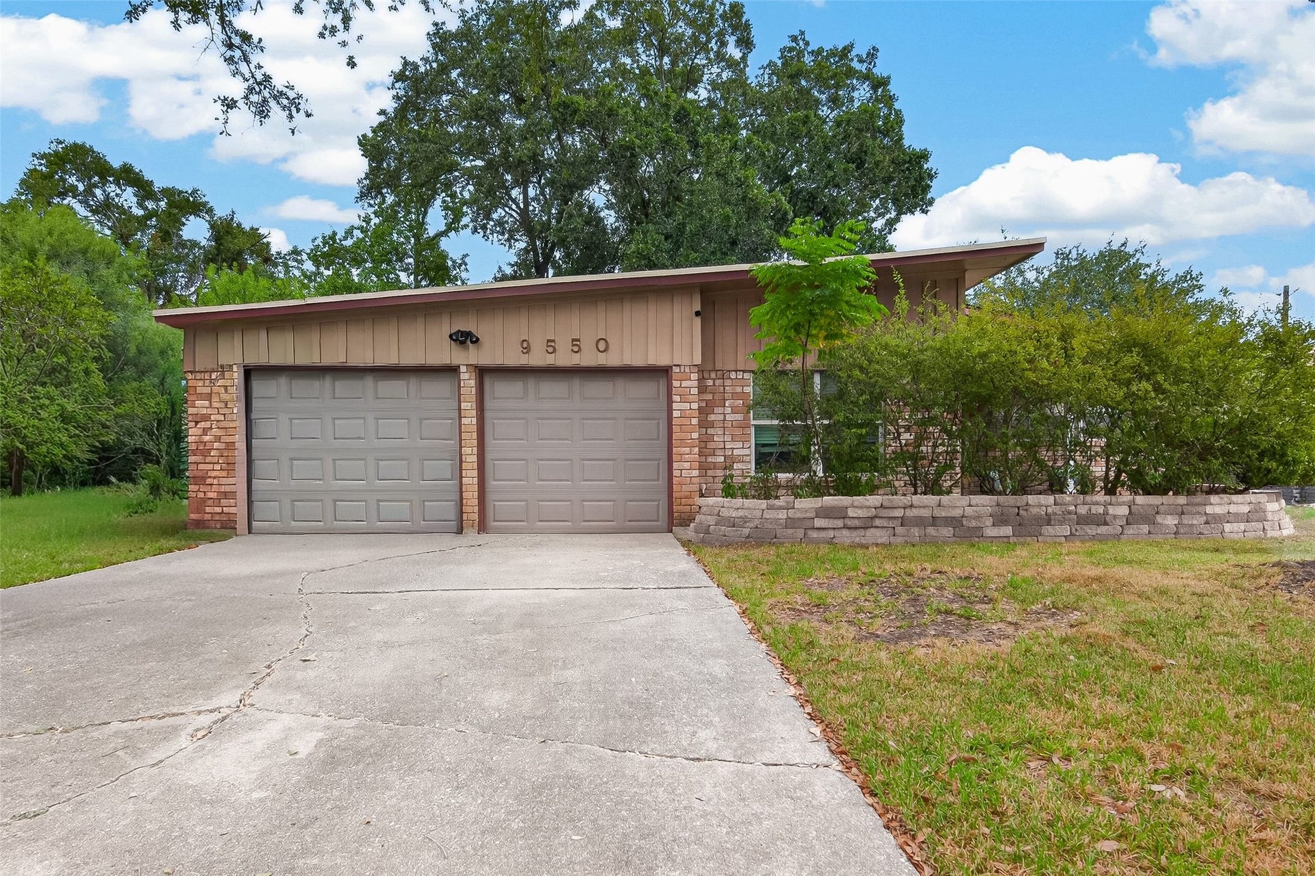 9550 Fairdale Lane, Houston, TX 77063 Charming mid-century home with a spacious two-car garage, offering a serene and private setting.
