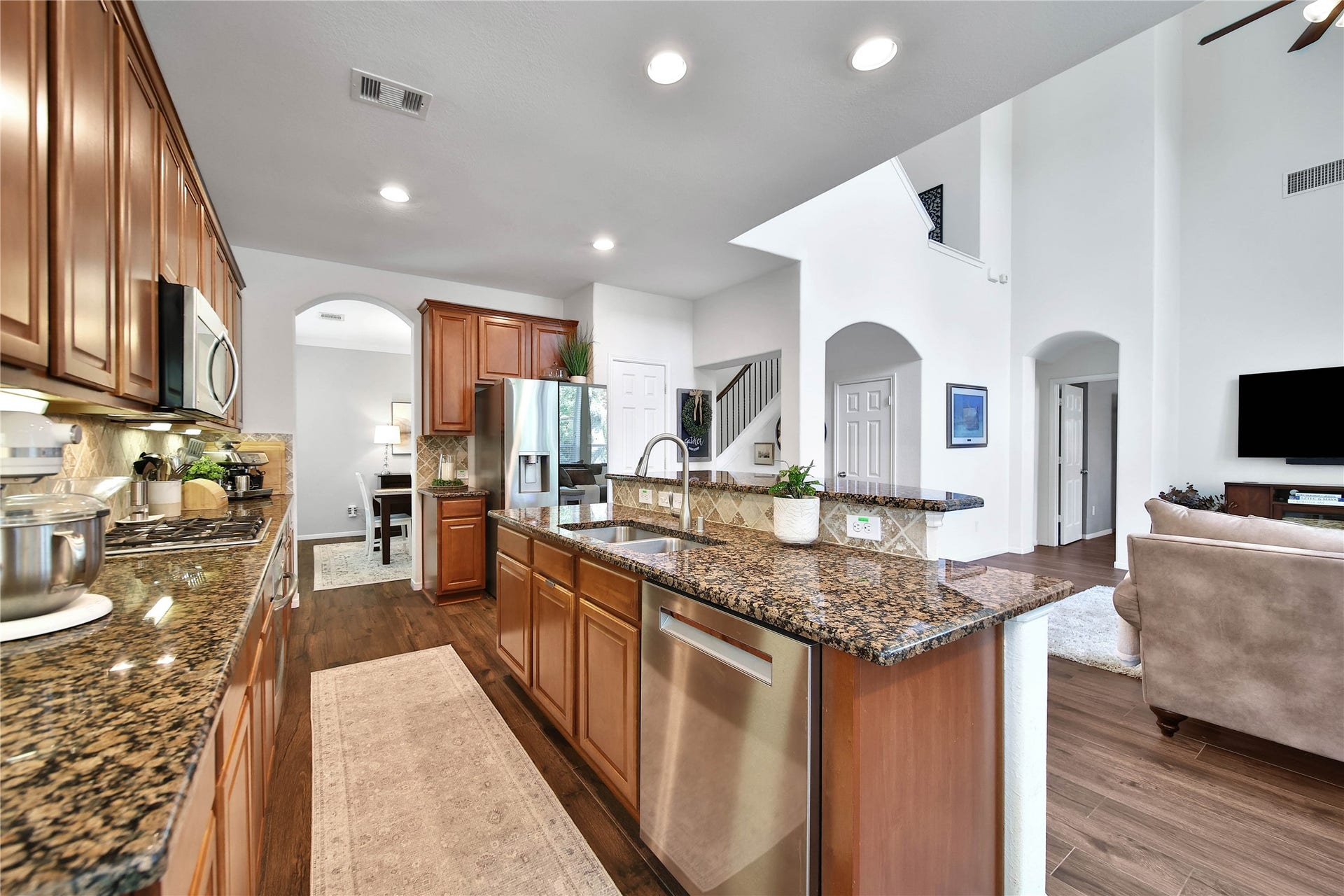 17311 Lassen Forest Lane, Humble, TX 77346 Functional kitchen design with wood cabinetry and granite countertops. Gas cooktop, and built-in oven. The Bosch dishwasher is an extra perk in this great space.
