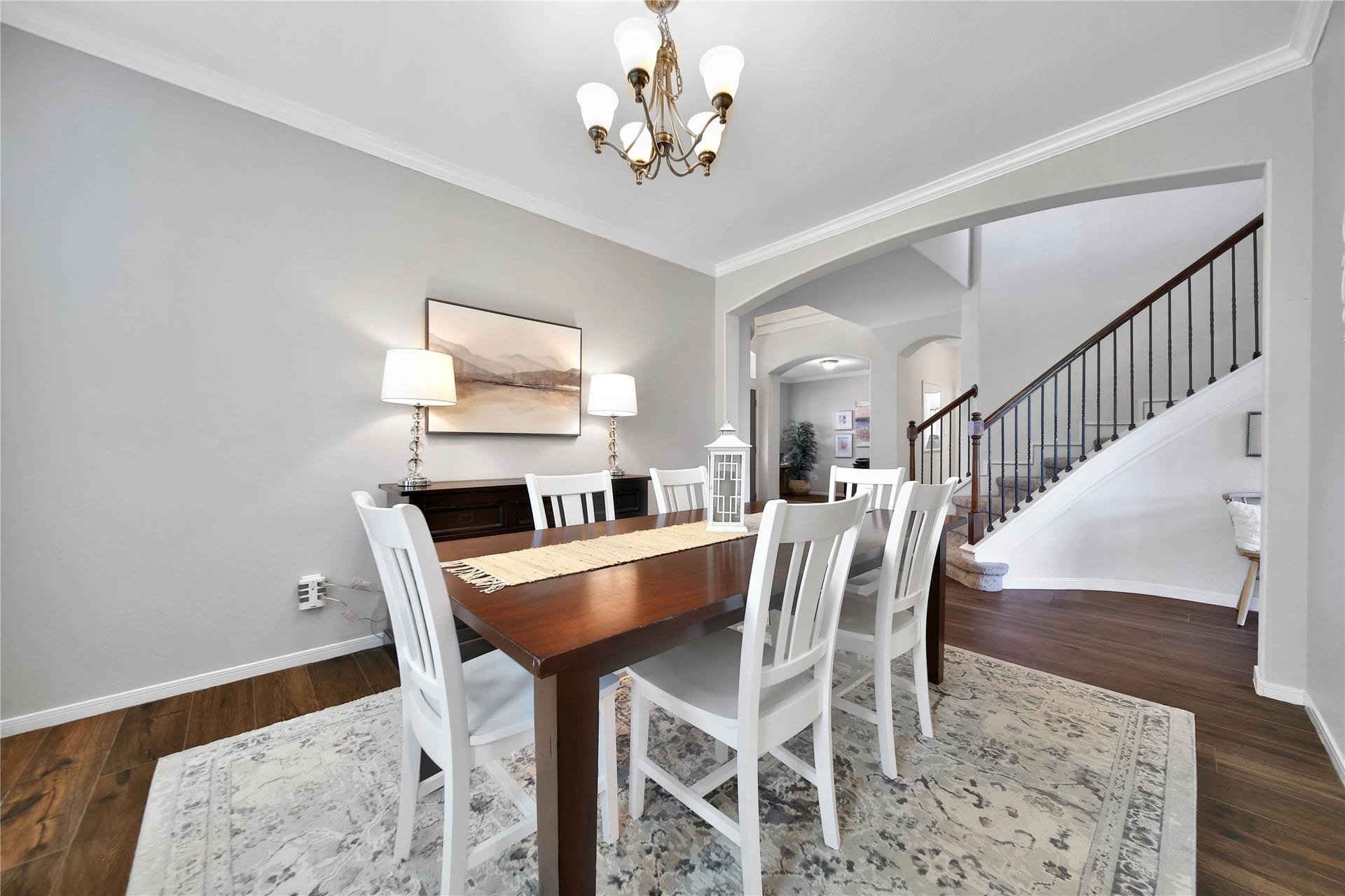 17311 Lassen Forest Lane, Humble, TX 77346 Spacious dining room with neutral color palette and gorgeous wood tile floors that extend through the main floor. Views of the foyer and iron staircase add to the visual appeal.