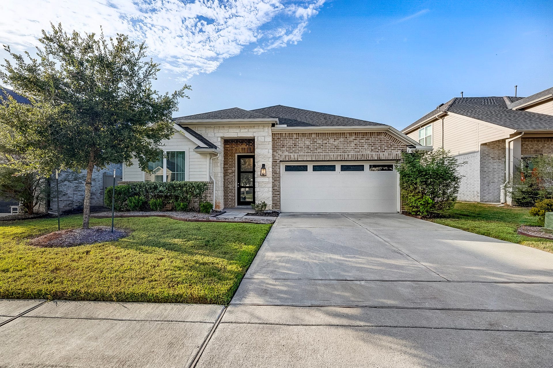 40638 Goldeneye Place, Magnolia, TX 77354 Charming single-story home with a brick facade and a welcoming front porch. The well-maintained lawn and trees enhance curb appeal, while the spacious driveway leads to a two-car garage.