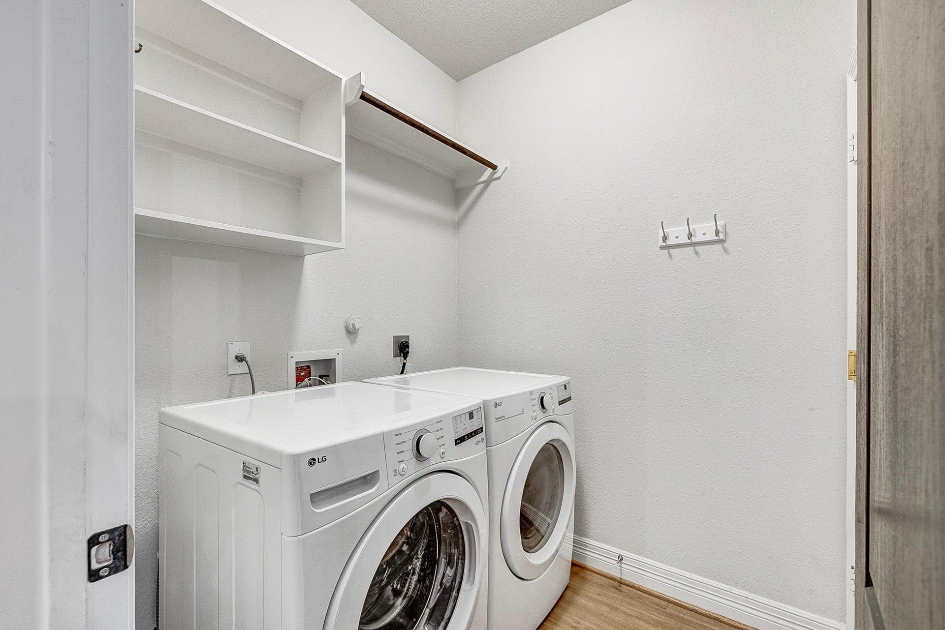 40638 Goldeneye Place, Magnolia, TX 77354 Convenient laundry room with modern washer and dryer, ample shelving, and hanging space for easy organization.