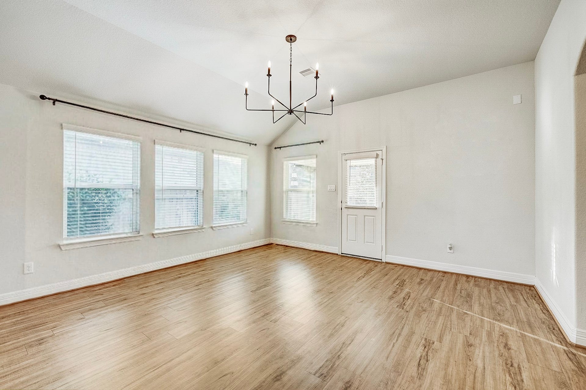 40638 Goldeneye Place, Magnolia, TX 77354 Bright and airy living space with large windows, elegant chandelier, and beautiful wood flooring.