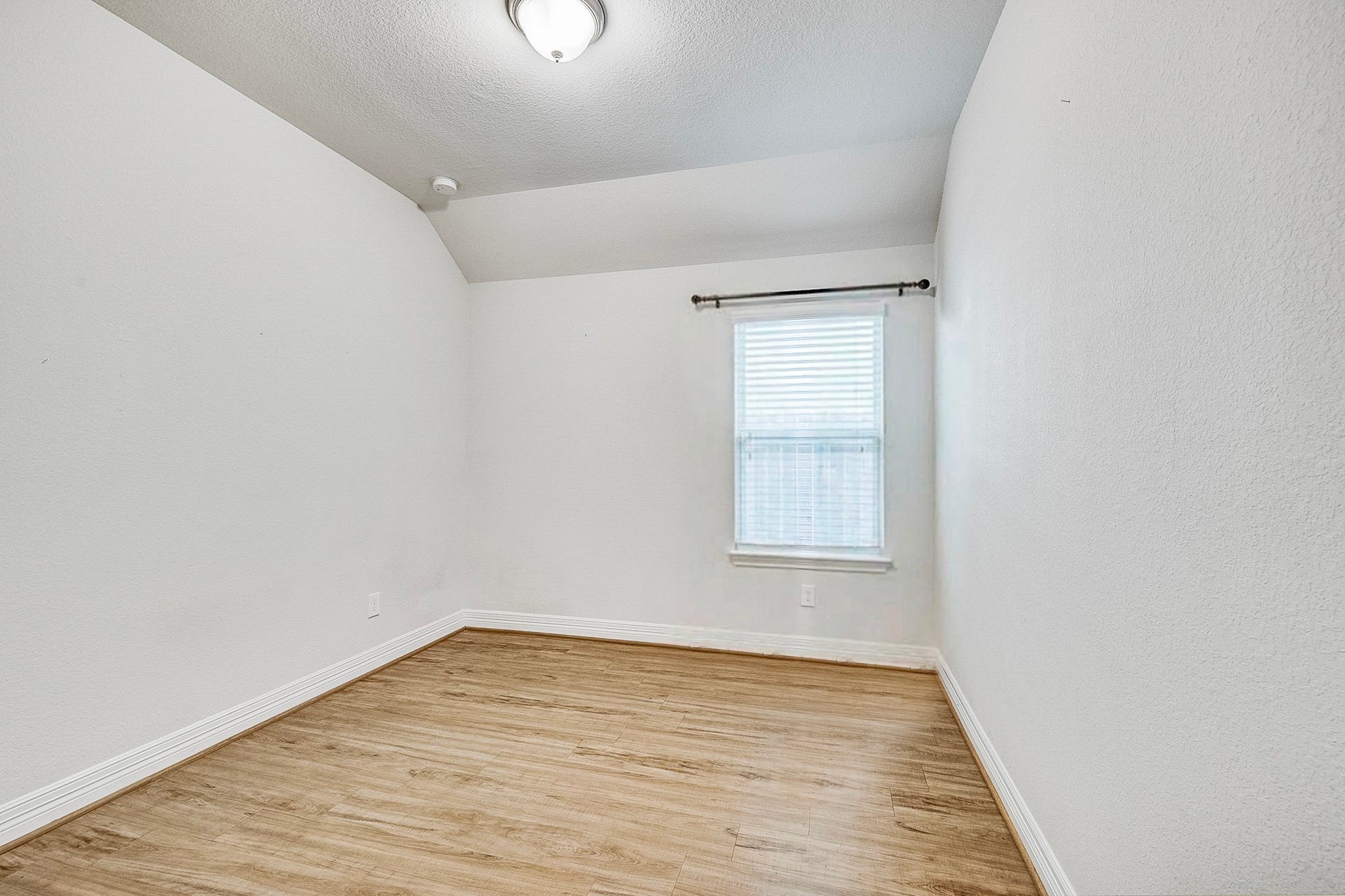 40638 Goldeneye Place, Magnolia, TX 77354 Bright and cozy room featuring hardwood floors, a single window for natural light, and clean white walls, perfect for a home office or guest room.