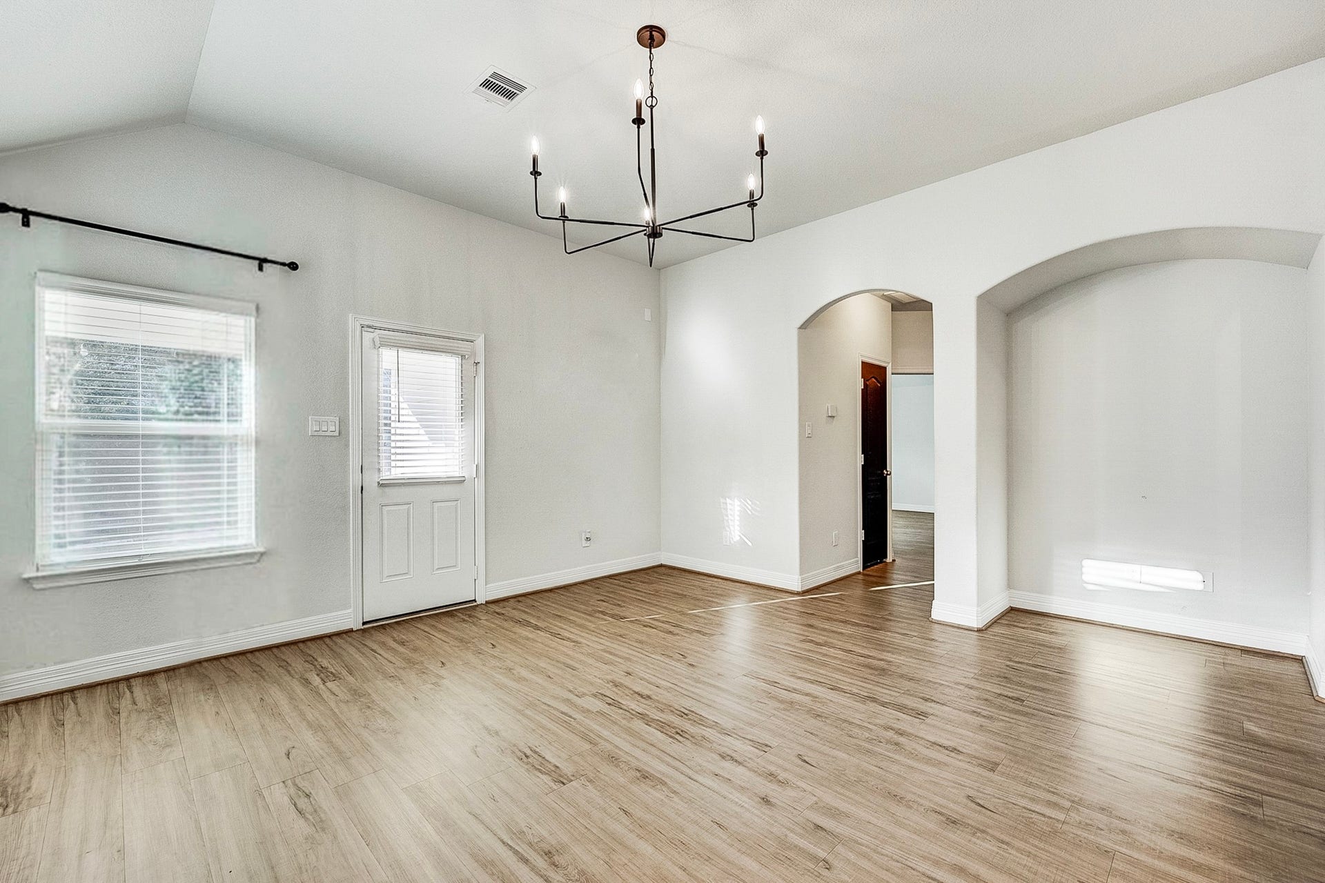 40638 Goldeneye Place, Magnolia, TX 77354 Bright and airy living space with high ceilings, elegant light fixture, and beautiful wood flooring, offering a welcoming and open atmosphere.