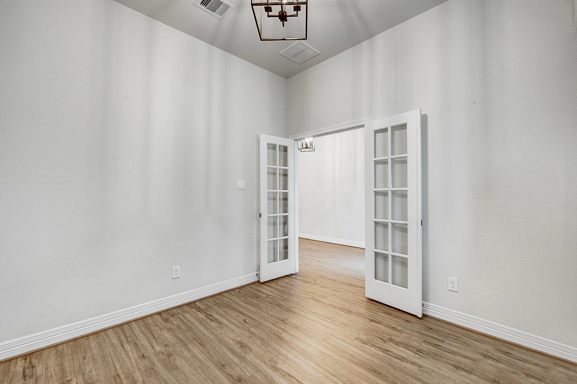 40638 Goldeneye Place, Magnolia, TX 77354 Elegant room featuring French doors and wood flooring, perfect for a home office or cozy retreat.