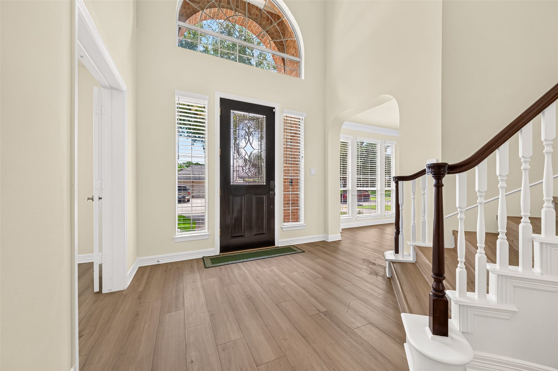 826 Ivory Ridge Lane, Houston, TX 77094 STEP INSIDE! Natural light pours into the elegant 2-story foyer through the dramatic arched transom window above the entry with sidelights flanking the leaded-glass front door. Fresh neutral interior paint throughout (2026) & Luxury Vinyl Plank (LVP) flooring (2026) create a light, welcoming introduction to the home. Arched openings offer inviting glimpses into the rooms beyond, with the formal dining room to one side & study to the other.