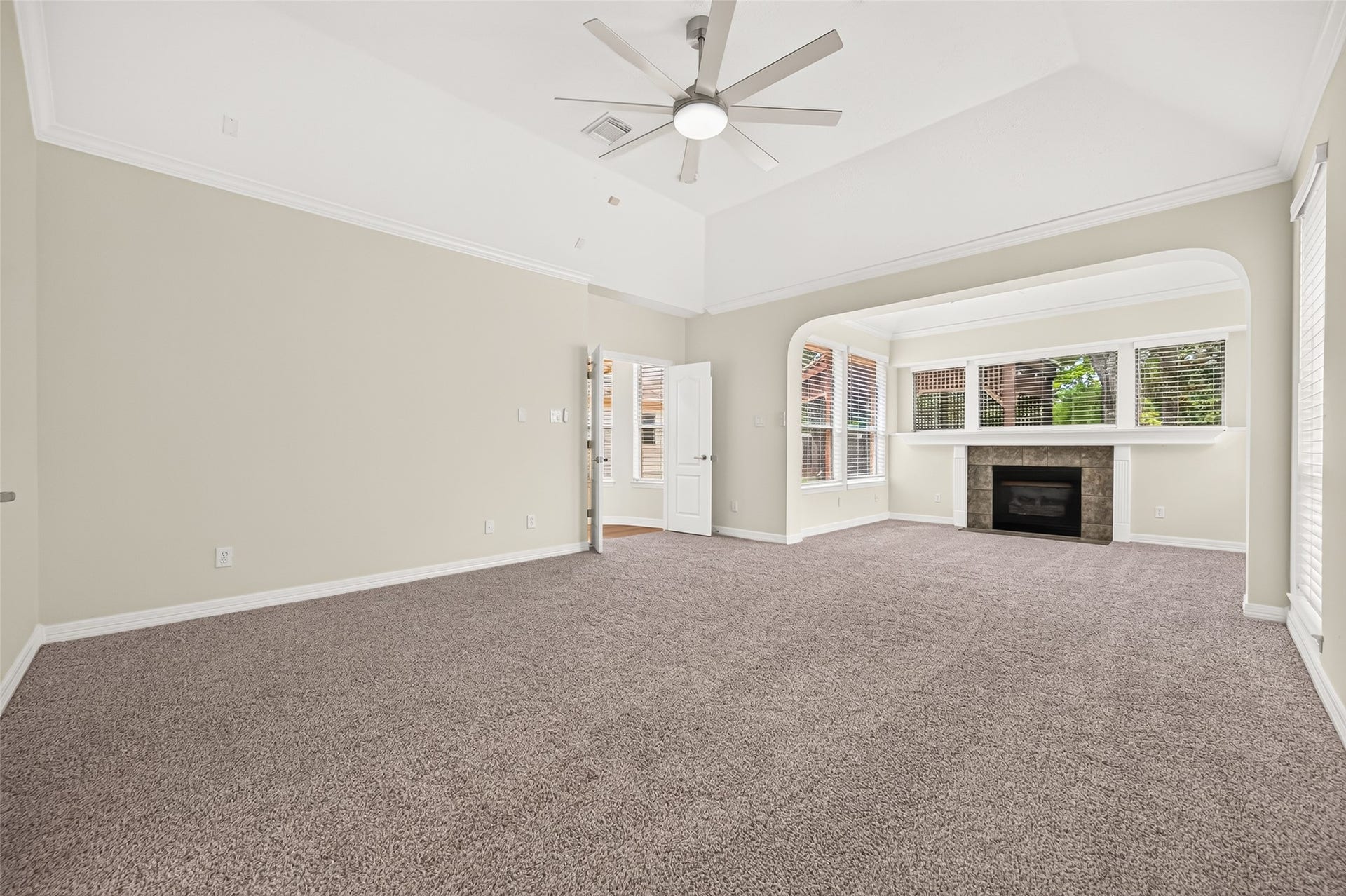 826 Ivory Ridge Lane, Houston, TX 77094 YOUR PRIVATE RETREAT! The spacious 1st-FLOOR PRIMARY SUITE offers plenty of room to unwind with brand new plush carpeting (2026), a dramatic high ceiling, crown molding & an updated ceiling fan. A wide arched opening leads into a separate sitting area with its own gas-log fireplace, creating a wonderful retreat within the suite. Generous wall space easily accommodates substantial bedroom furniture while still leaving plenty of room to move about.