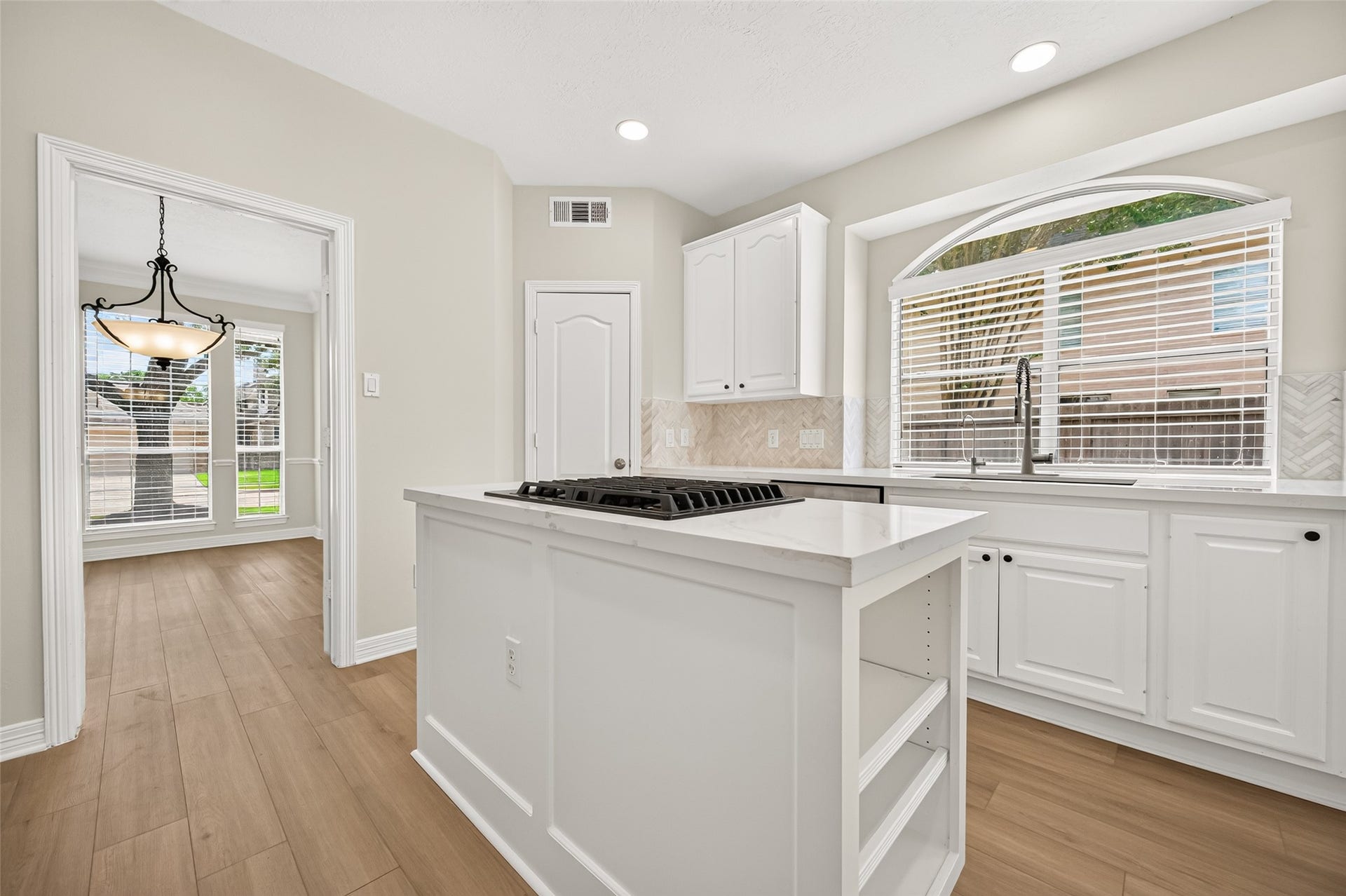 826 Ivory Ridge Lane, Houston, TX 77094 Even washing dishes comes with a view! A single-basin composite farmhouse sink with updated faucet sits beneath the large arched window overlooking the driveway, bringing abundant natural light to the workspace. The generous single basin easily accommodates larger items like baking sheets & crockpots. A stainless steel Bosch dishwasher makes cleanup easier, while the large, lighted corner walk-in pantry provides generous storage for groceries, small appliances, & everyday kitchen essentials.