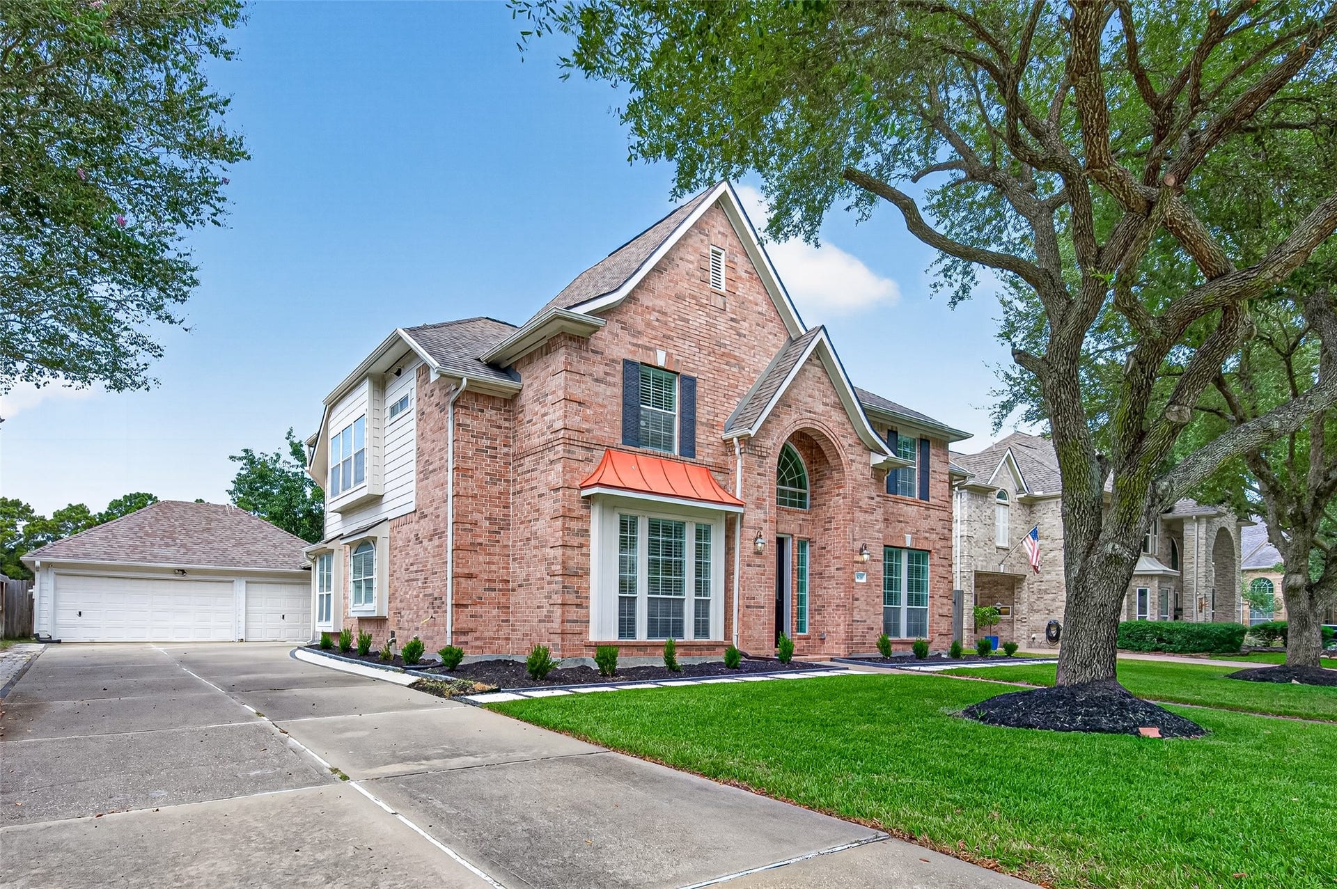 826 Ivory Ridge Lane, Houston, TX 77094 THERE'S MORE TO LOVE! This view showcases the home's classic brick & Hardie exterior, architectural details like the bay window with metal roof, and mature shade trees while revealing the 3-CAR DETACHED GARAGE tucked behind the home. The expanded driveway with brick paver accents on each side provides generous parking space while keeping the garage from competing with the home's beautiful front elevation. Roof replaced in 2015. Gutters & double-pane windows add to the home's thoughtful features.