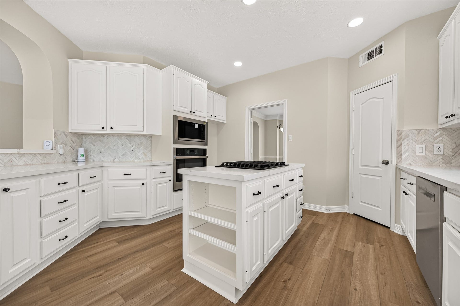826 Ivory Ridge Lane, Houston, TX 77094 Everything has its place! The kitchen features a Frigidaire microwave (2026) & GE oven (2026), conveniently built into the surrounding cabinetry. To the right, the designated space accommodates a full-size refrigerator. The island offers even more storage with drawers, cabinets, & open shelving at one endan ideal spot to keep favorite cookbooks close at hand when its time to try a new recipe.