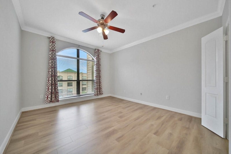 2299 Lone Star Drive, #406, Sugar Land, TX 77479 The view of secondary bedroom W/New wood flooring, crown molding and ceiling fan.