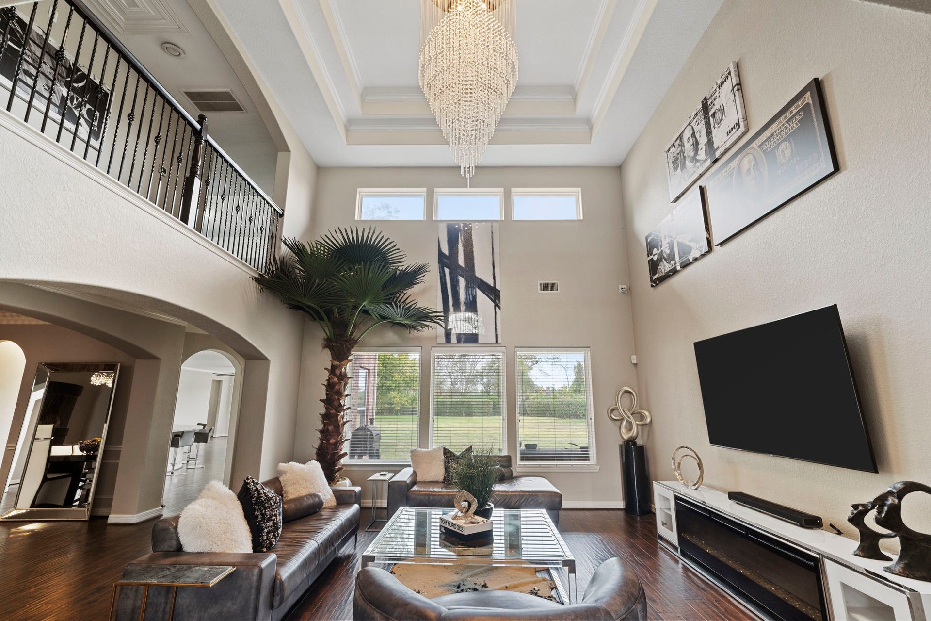 4502 Creek Point Lane, Missouri City, TX 77459 Impressive two-story living room featuring soaring ceilings and a dramatic wall of windows that fills the space with natural light.