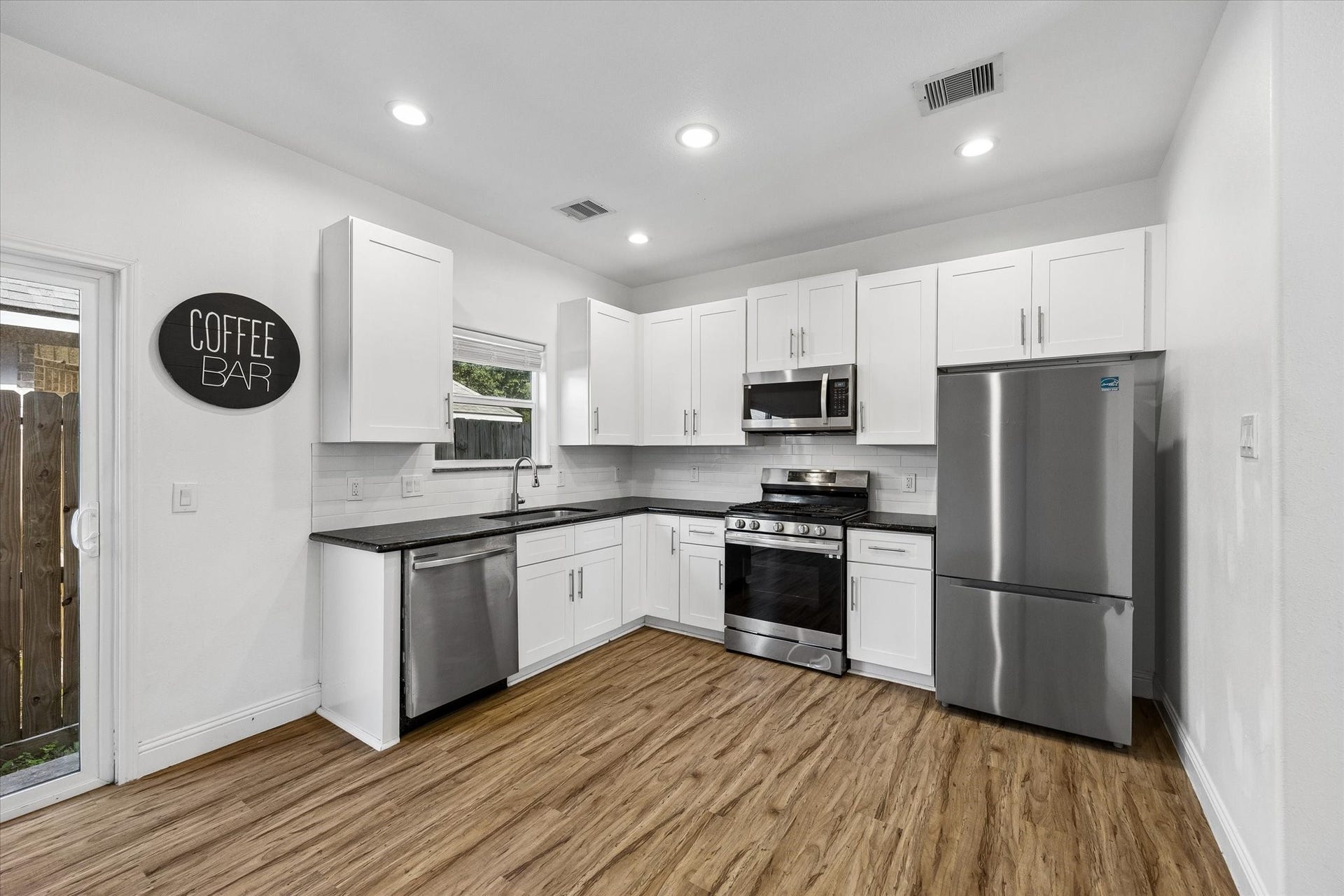 3515 Shelby Circle, #A/B, Houston, TX 77051 The bright and airy open concept kitchen and dining offers stainless steel appliances, natural light from the kitchen window and sliding glass door, ample storage, and soft close cabinets and drawers.