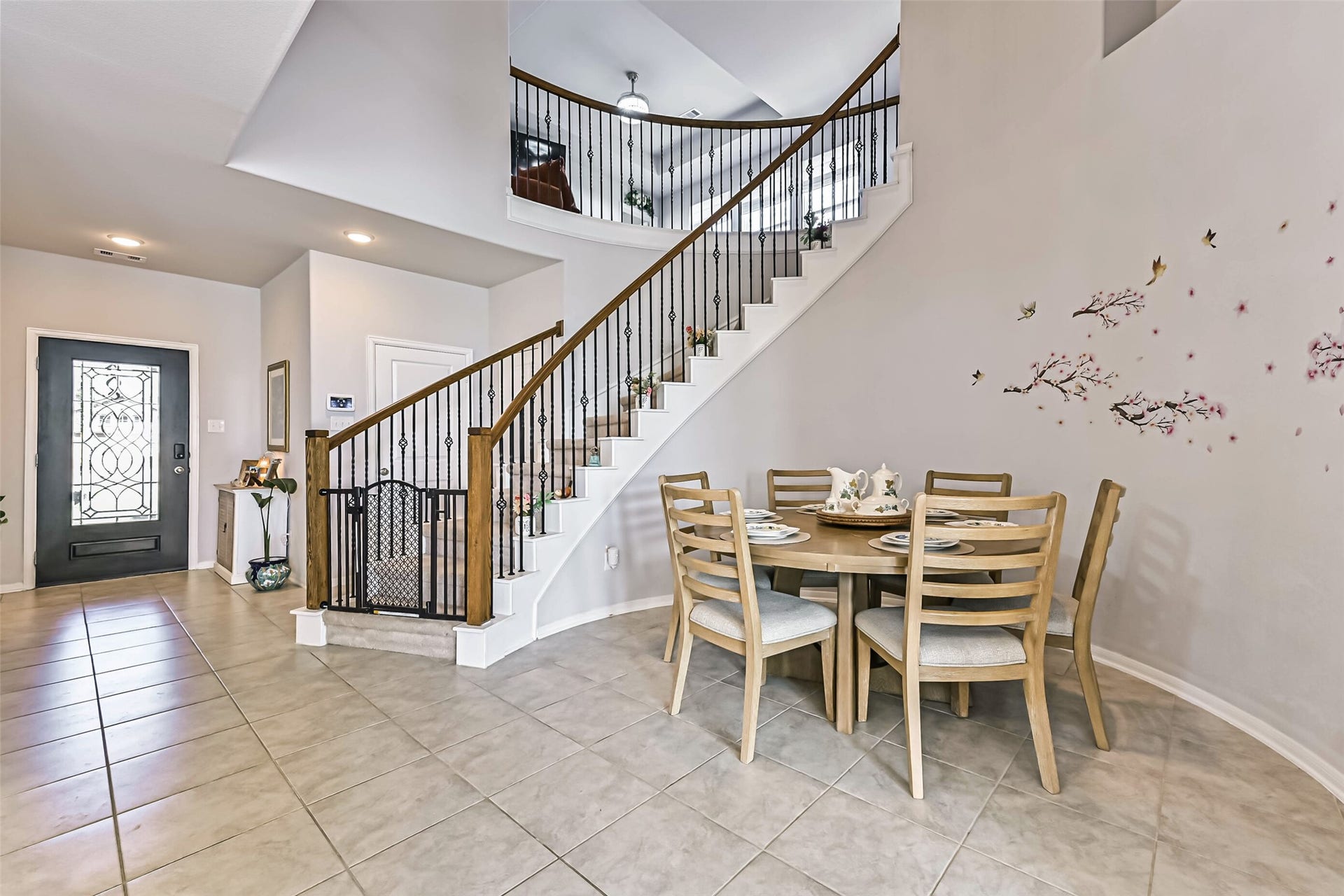 12527 Jetty Cove Drive, Texas City, TX 77568 Charming dining area highlighted by a beautiful, curved staircase with wrought-iron detailing, creating an inviting space for everyday meals and gatherings.