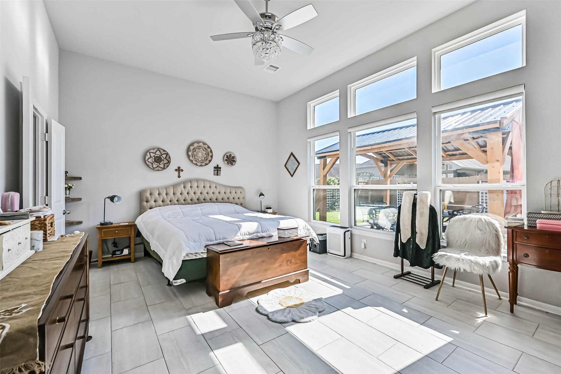 12527 Jetty Cove Drive, Texas City, TX 77568 Spacious primary bedroom featuring high ceilings, abundant natural light, a wall of windows, and a ceiling fan with decorative lighting.