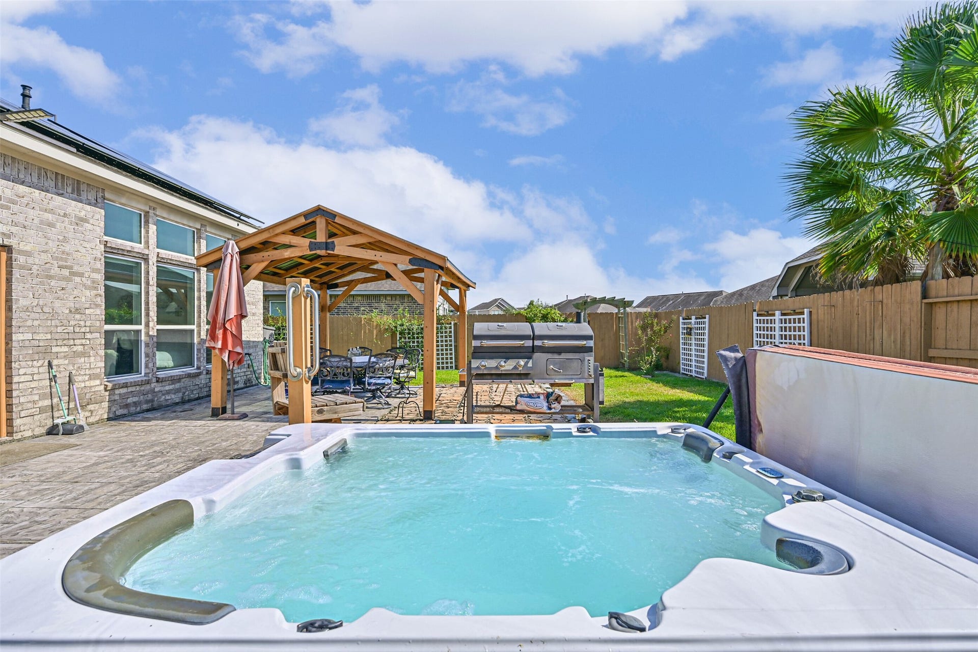 12527 Jetty Cove Drive, Texas City, TX 77568 Expansive patio with a private hot tub and covered seating area, creating the perfect setting for relaxing evenings and weekend gatherings.