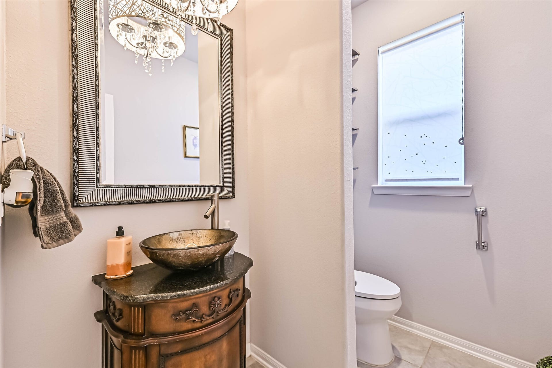 12527 Jetty Cove Drive, Texas City, TX 77568 Charming half bath featuring a decorative vessel sink, custom-style vanity, framed mirror, and elegant light fixture.