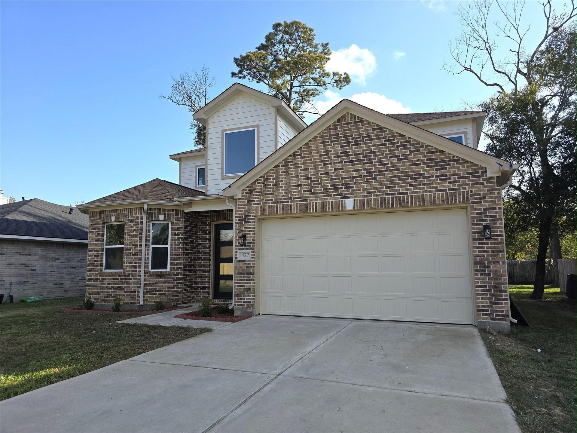 Charming two-story brick home with a spacious two-car garage and inviting front entrance.