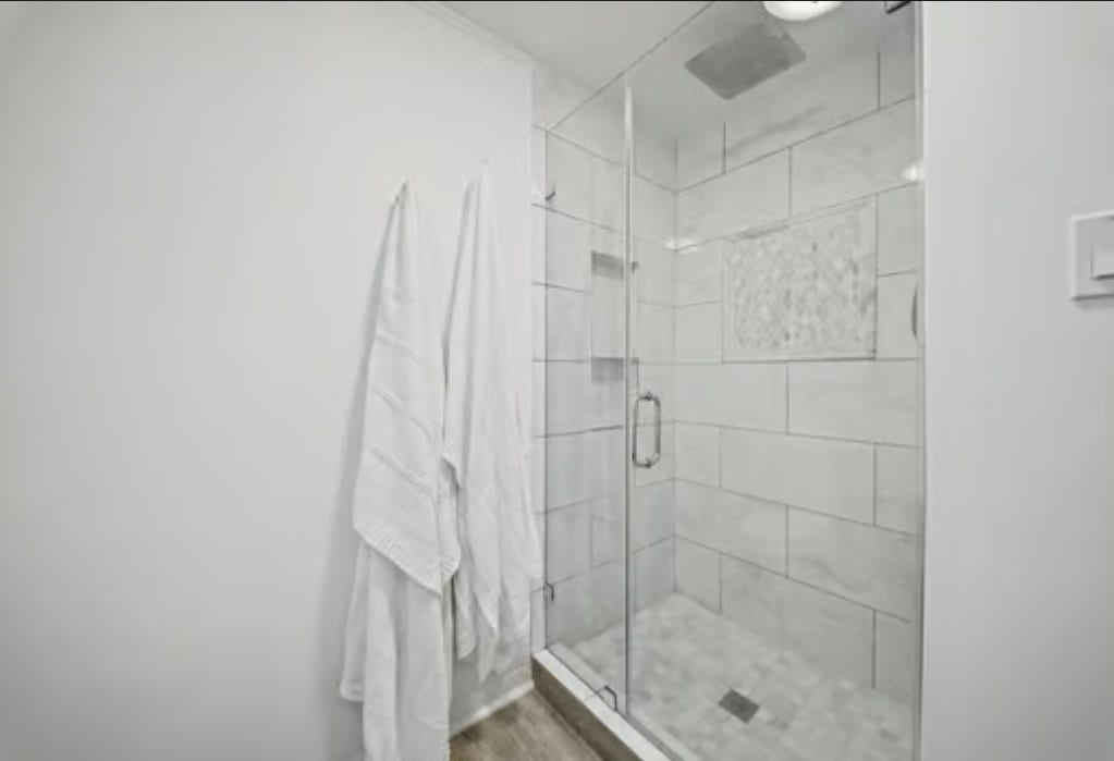 2555 Bering Drive, #1, Houston, TX 77057 Sleek, modern shower with glass doors and elegant tilework offers a refreshing retreat.