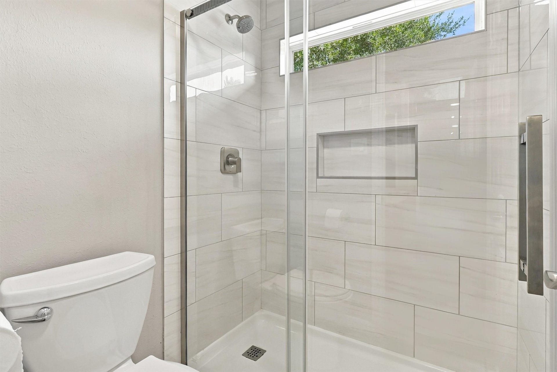 1030 Barkston Drive, Katy, TX 77450 This bathroom also features a walk in shower with a neutral tile surround, a side window for natural light, and a sliding glass enclosure.
