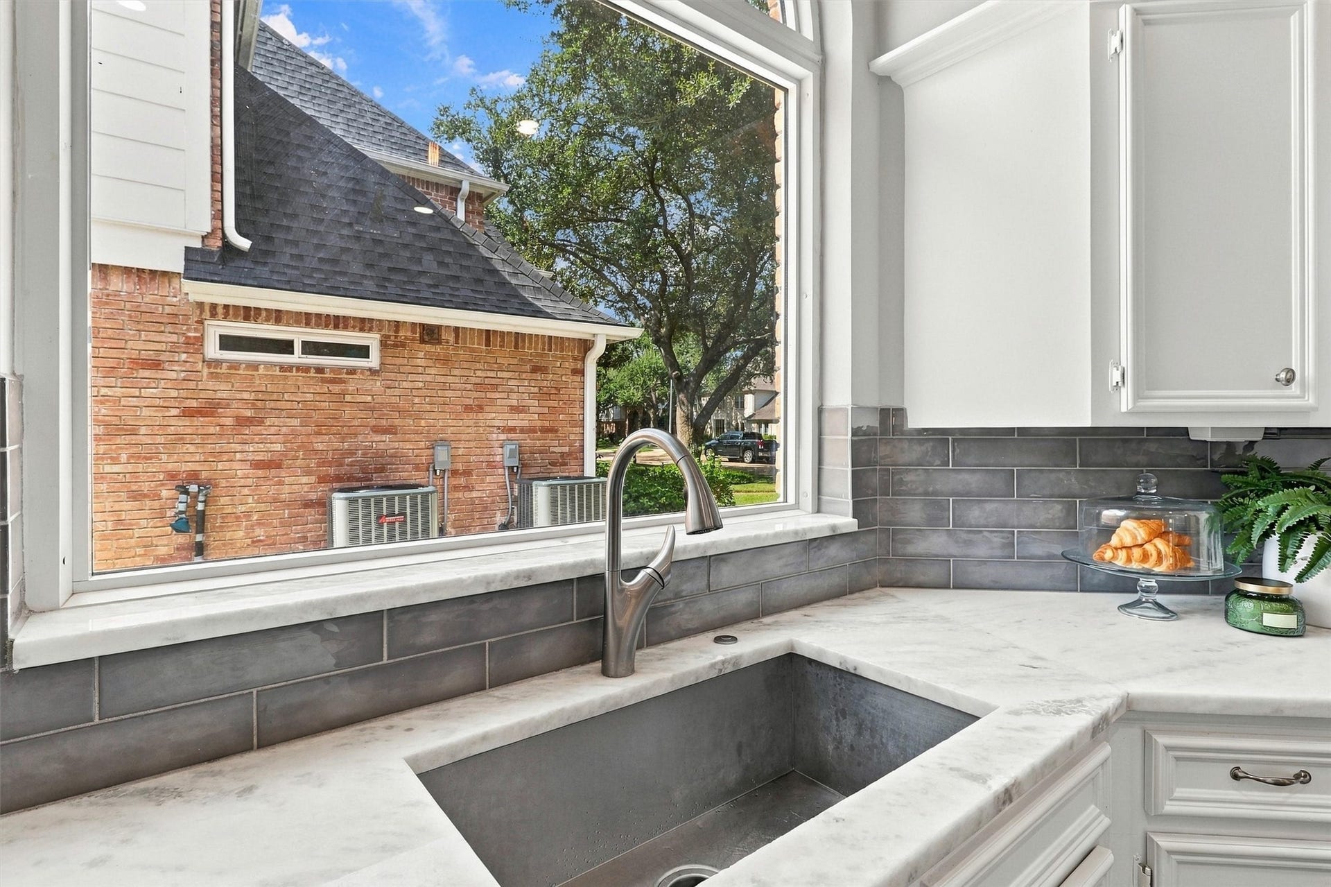 1030 Barkston Drive, Katy, TX 77450 The single basin undermount sink is situated beneath an arched picture window that offers a clear view of the driveway and floods the space with natural light.