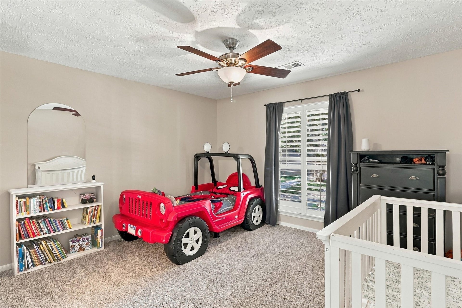 1030 Barkston Drive, Katy, TX 77450 Guest bedroom number one offers plush carpet, a ceiling fan, neutral paint, and a window overlooking the front yard.