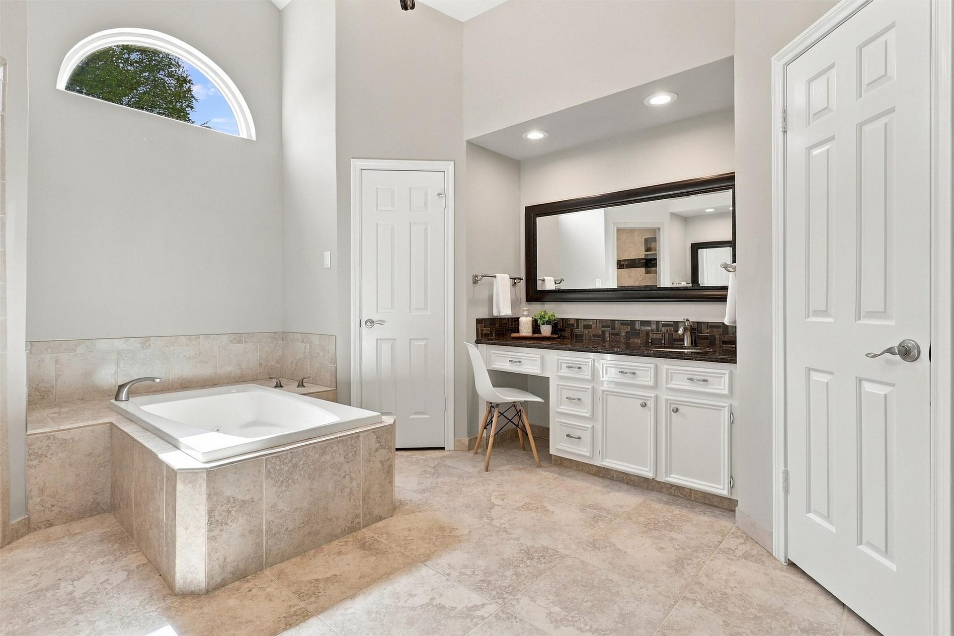 1030 Barkston Drive, Katy, TX 77450 The vanities mirror each other, offering sleek countertops, white cabinetry, framed mirrors, and recessed lighting. This vanity in particular includes a seating area, perfect for getting ready for the day, while the high ceiling gives the entire room a grand feel.