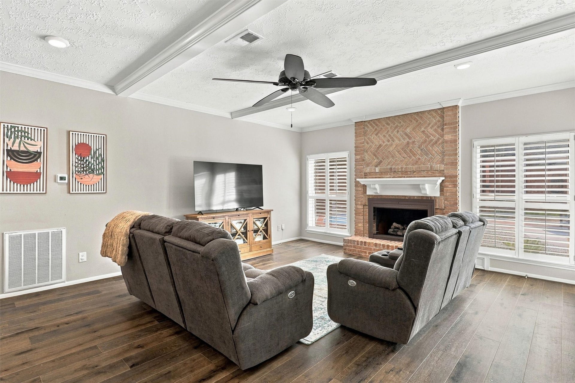 1030 Barkston Drive, Katy, TX 77450 The open concept living area is anchored by a charming brick fireplace and warmed by hardwood floors and an abundance of natural light throughout.