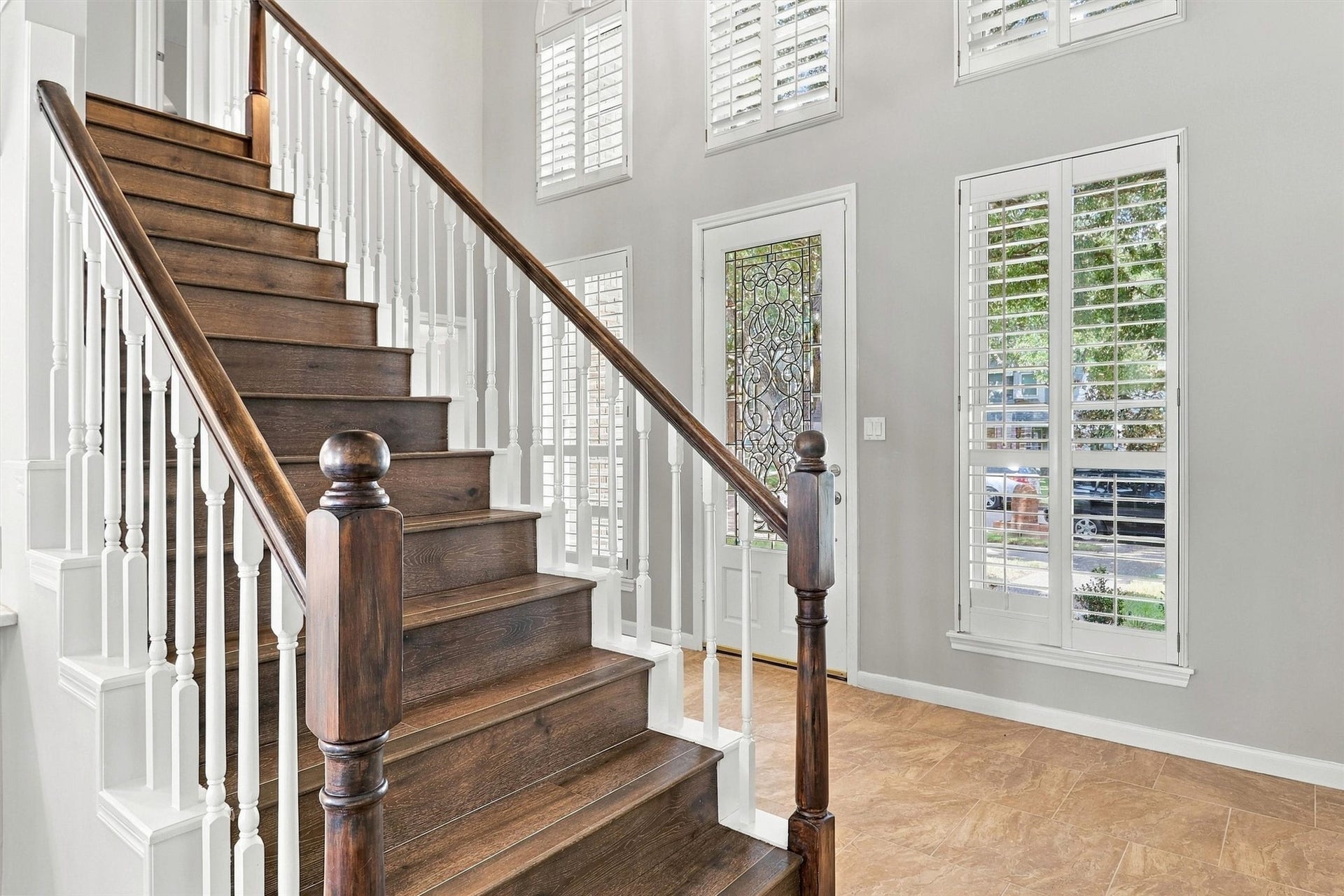 1030 Barkston Drive, Katy, TX 77450 As you walk in, you are greeted with this front foyer featuring a leaded glass door and two stories of surrounding windows that flood the space with natural light.