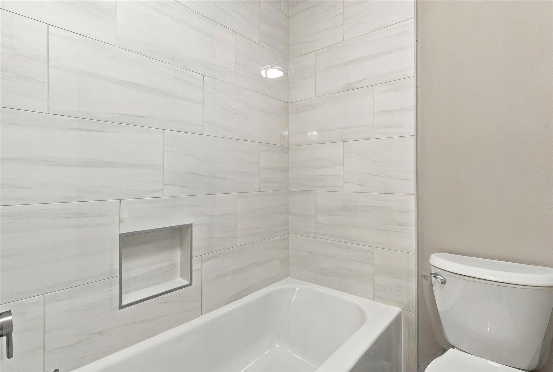 1030 Barkston Drive, Katy, TX 77450 The Hollywood bathroom also includes this updated tub and shower combination, finished with a beautiful neutral tile surround.