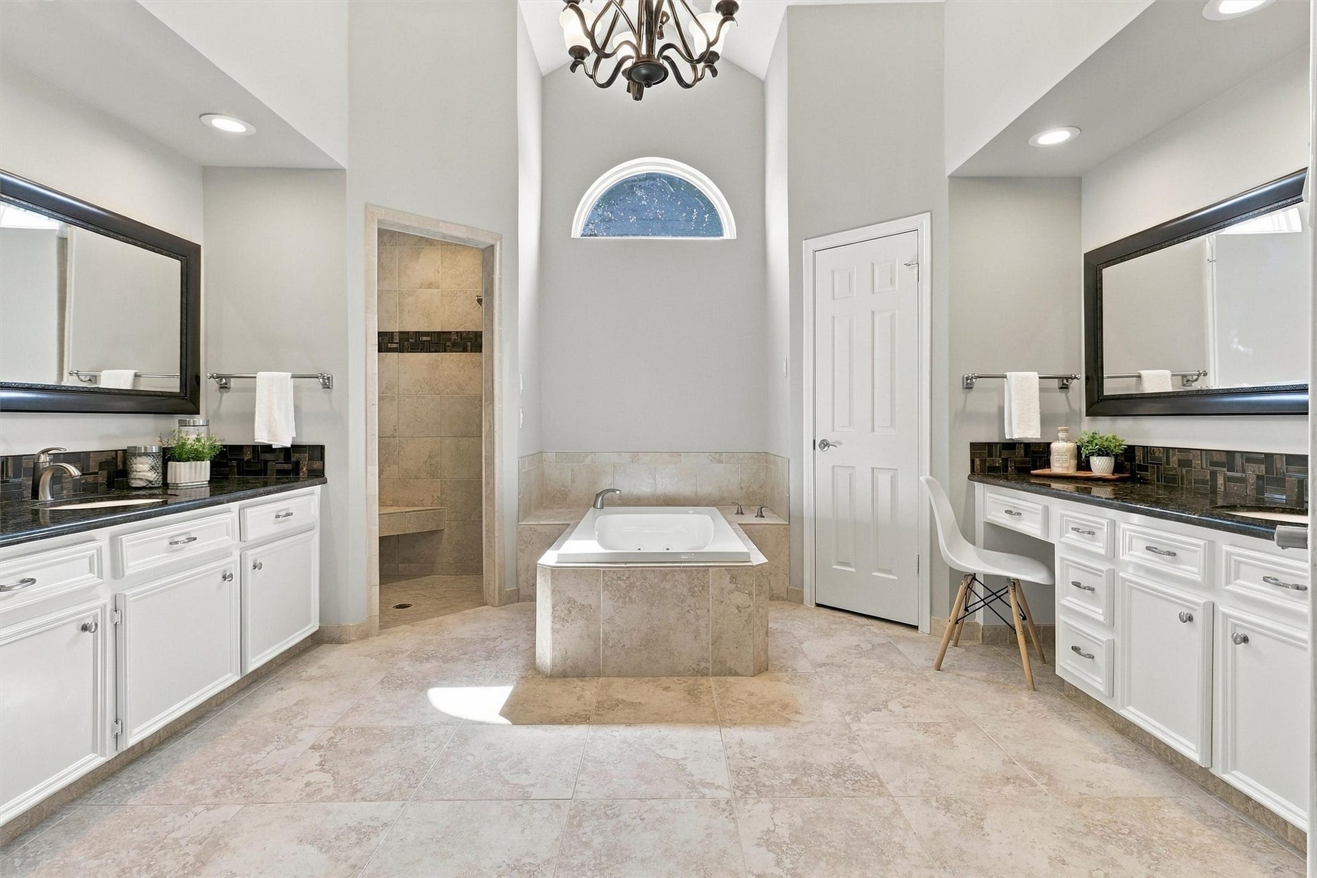 1030 Barkston Drive, Katy, TX 77450 Welcome to your spa like primary bathroom, featuring a stunning vaulted ceiling and a jetted soaking tub that serves as a striking centerpiece beneath an elegant chandelier. Dual vanities each with their own sink complete this thoughtfully designed retreat.