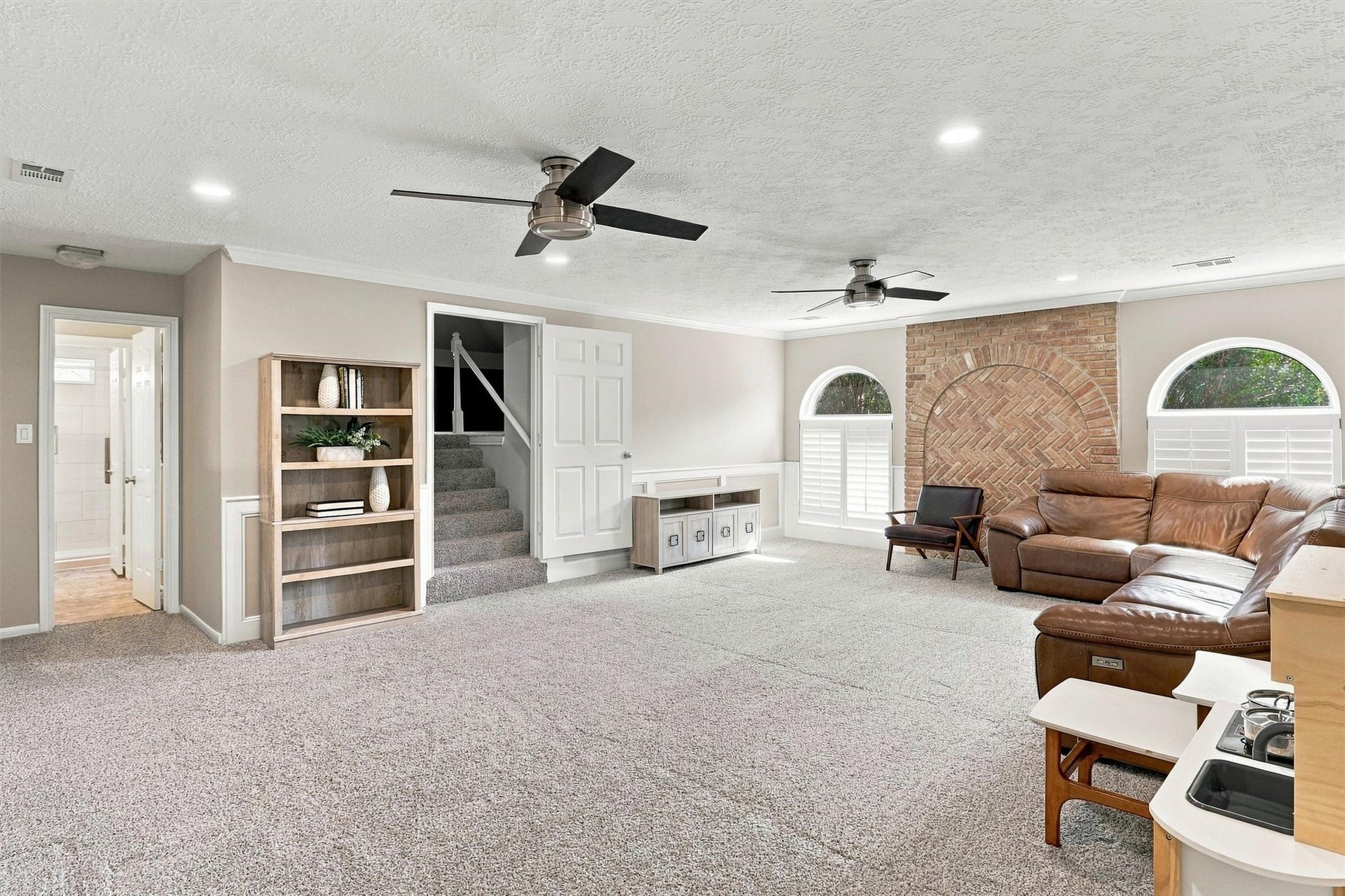 1030 Barkston Drive, Katy, TX 77450 Wow, this spacious gameroom has so much to offer, including plush carpet, multiple ceiling fans, recessed lighting, and crown molding. A gorgeous brick accent wall with an arch beautifully complements the arched windows throughout the space.