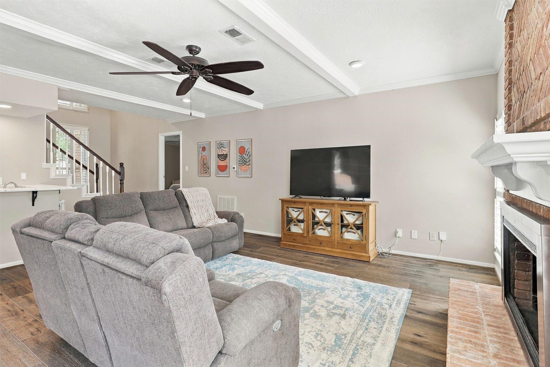1030 Barkston Drive, Katy, TX 77450 The living room features beautiful ceiling beams that add architectural dimension, along with a ceiling fan, a convenient wet bar, and a charming fireplace.
