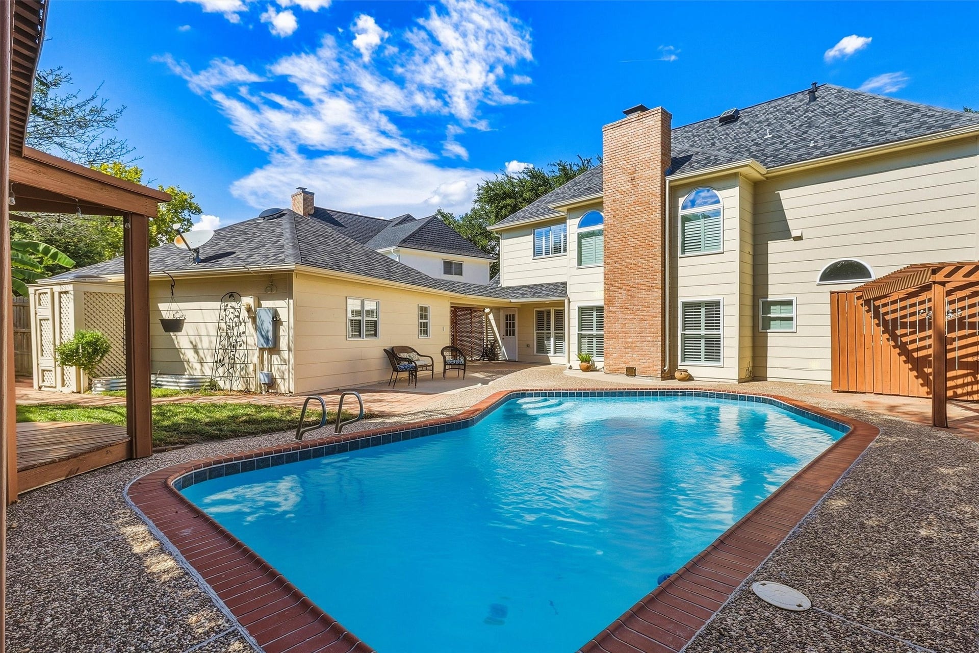 1030 Barkston Drive, Katy, TX 77450 An alternate view of the backyard showcases the abundance of decking, perfect for lounging or setting up your outdoor patio furniture. A toilet and shower located behind the garage make hosting pool parties that much more convenient.