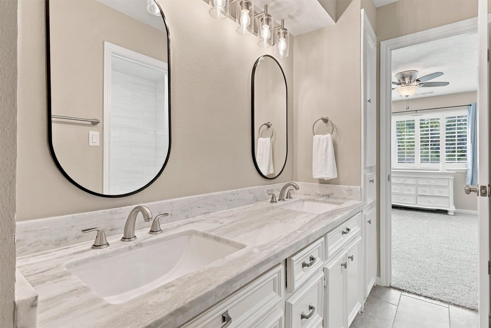 1030 Barkston Drive, Katy, TX 77450 This Hollywood bathroom is stunning, offering neutral tile floors, a vanity with dual sinks, granite countertops, framed mirrors, and updated lighting fixtures. This bathroom is perfect for sharing between two rooms!