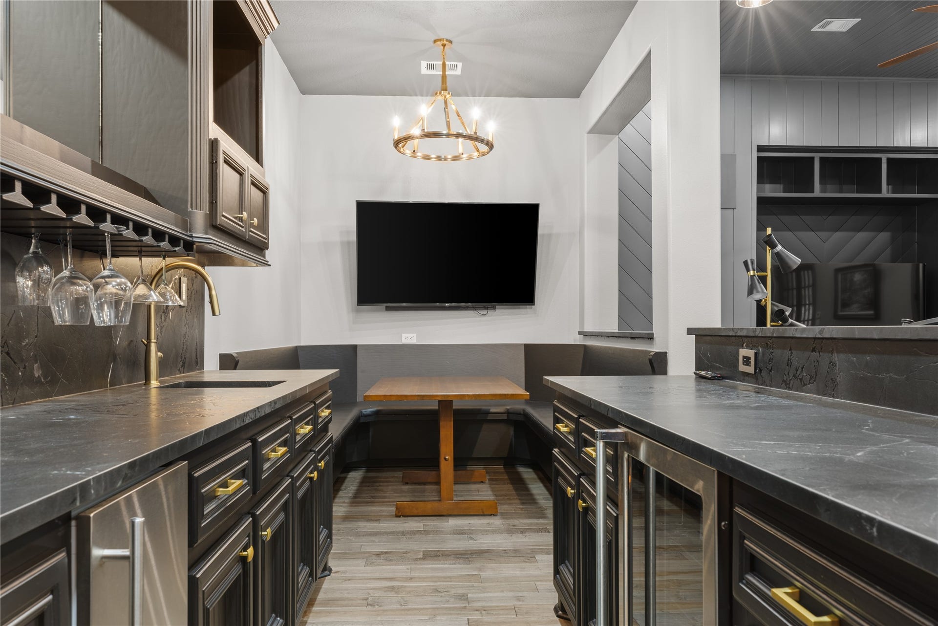Bar with sink, wine fridge, mini fridge and built in seating area
