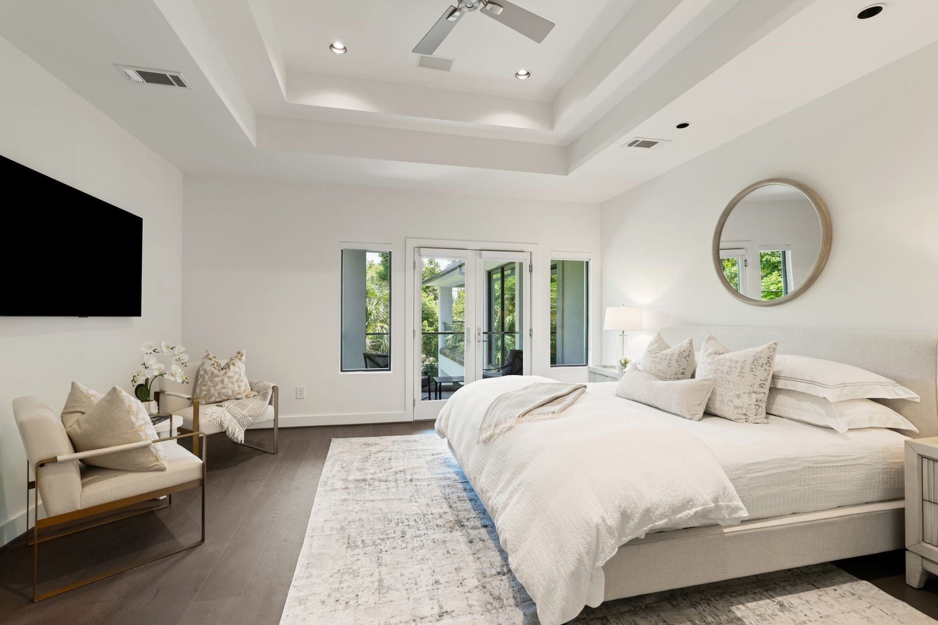 3703 Wroxton Road, West University Place, TX 77005 The spacious primary suite is a private retreat featuring a tray ceiling, serene sitting area, and a private balcony overlooking the resort-style pool and lush backyard.
