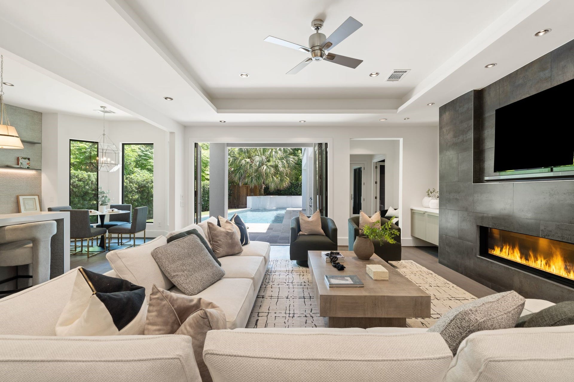 3703 Wroxton Road, West University Place, TX 77005 Designed for effortless entertaining, the spacious family room features a dramatic linear fireplace and walls of sliding glass that open directly to the sparkling pool and outdoor living spaces.