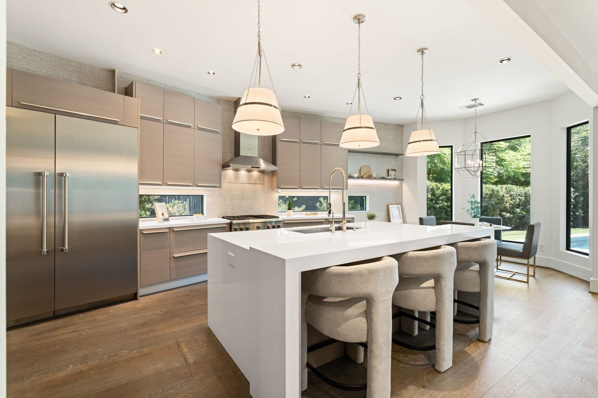 3703 Wroxton Road, West University Place, TX 77005 Designed for both entertaining and everyday living, the gourmet kitchen offers an expansive island, professional-grade appliances, sleek custom cabinetry, and sunlit breakfast area overlooking the pool.