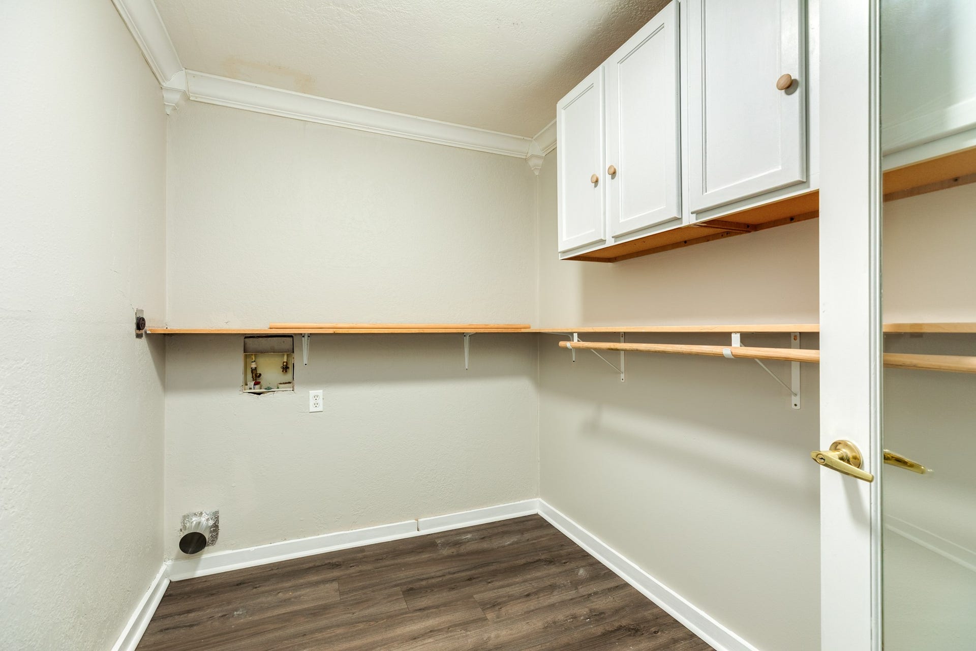 1602 County Road 939, Sweeny, TX 77480 Dedicated laundry and utility space offers washer and dryer hookups, extensive open shelving, and overhead cabinetry for additional storage. Wood-look flooring and neutral finishes create a practical, versatile area.
