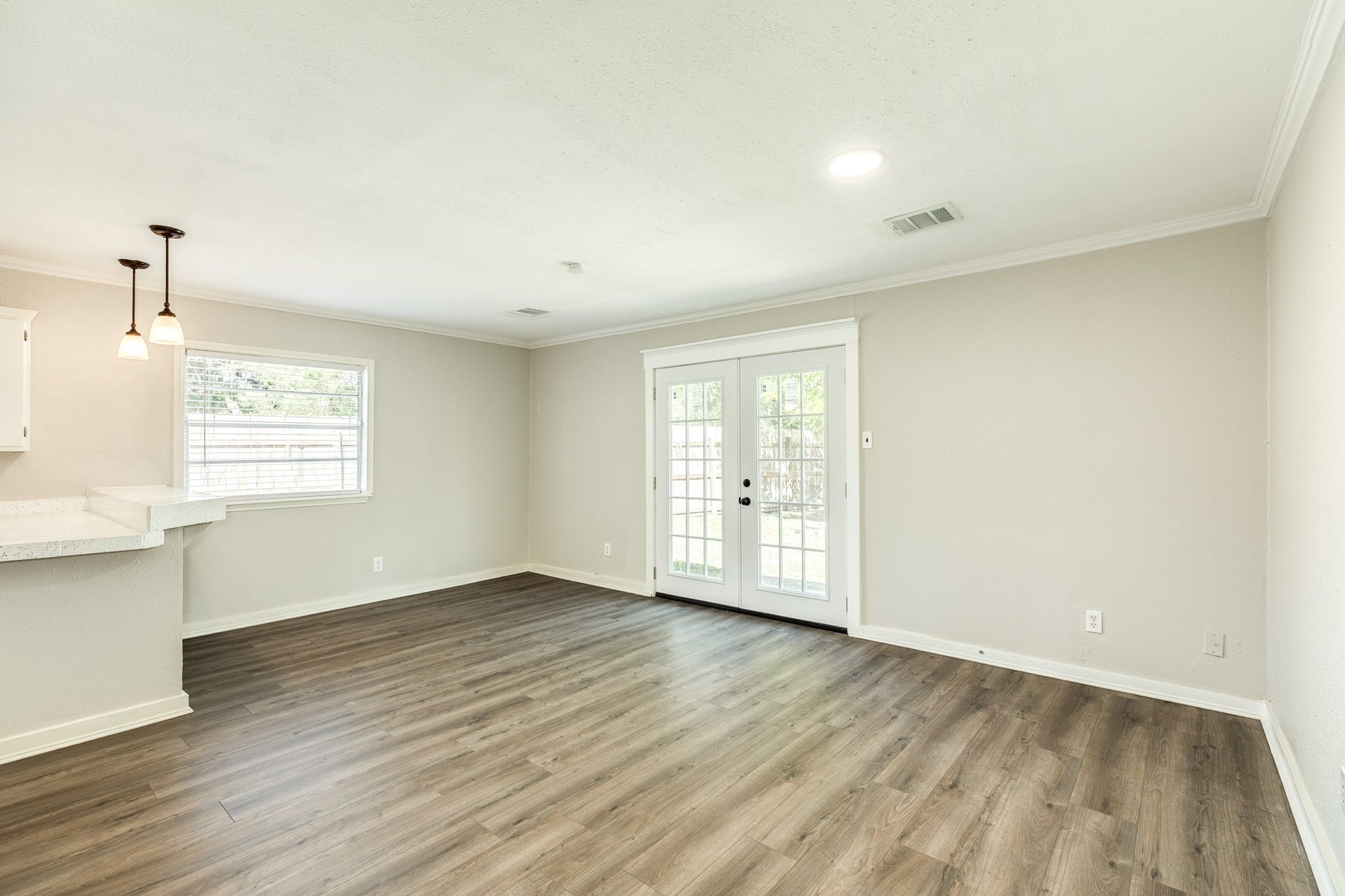 1602 County Road 939, Sweeny, TX 77480 Spacious dining area offers flexible furniture arrangements, durable wood-look flooring, and French doors overlooking the outdoor space. A breakfast bar with pendant lighting provides a convenient connection to the kitchen.