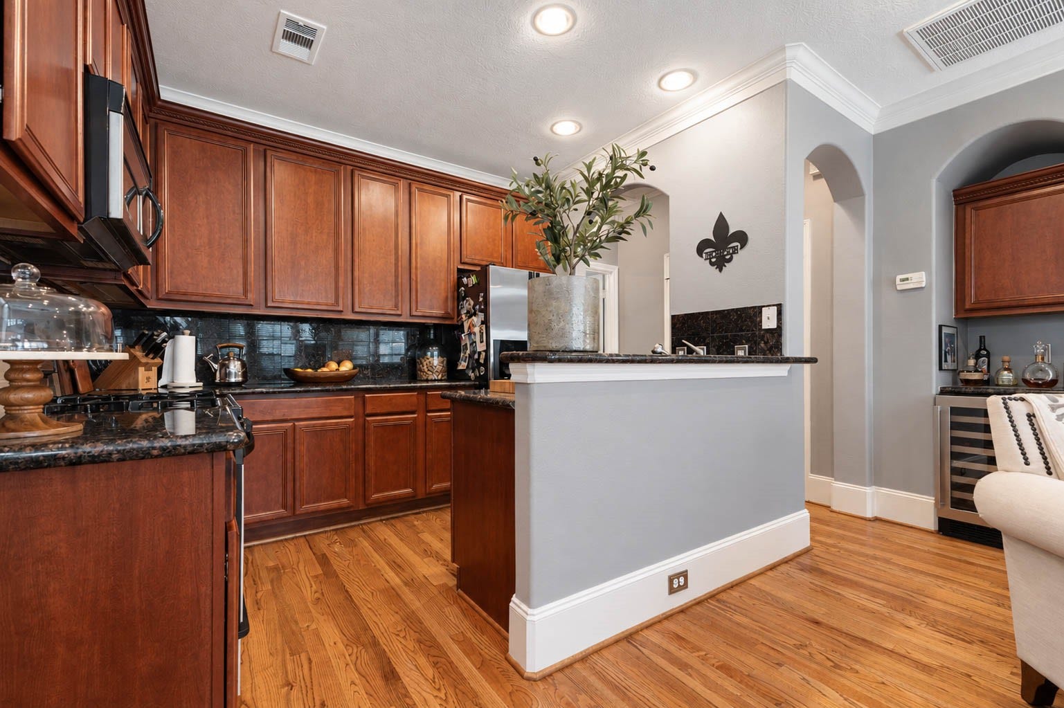 1316 Studer Street, Houston, TX 77007 The kitchen offers a rich, timeless presentation with abundant custom 42" wood cabinetry, granite countertops, stainless steel appliances, and a functional layout overlooking the adjoining living and dining areas.