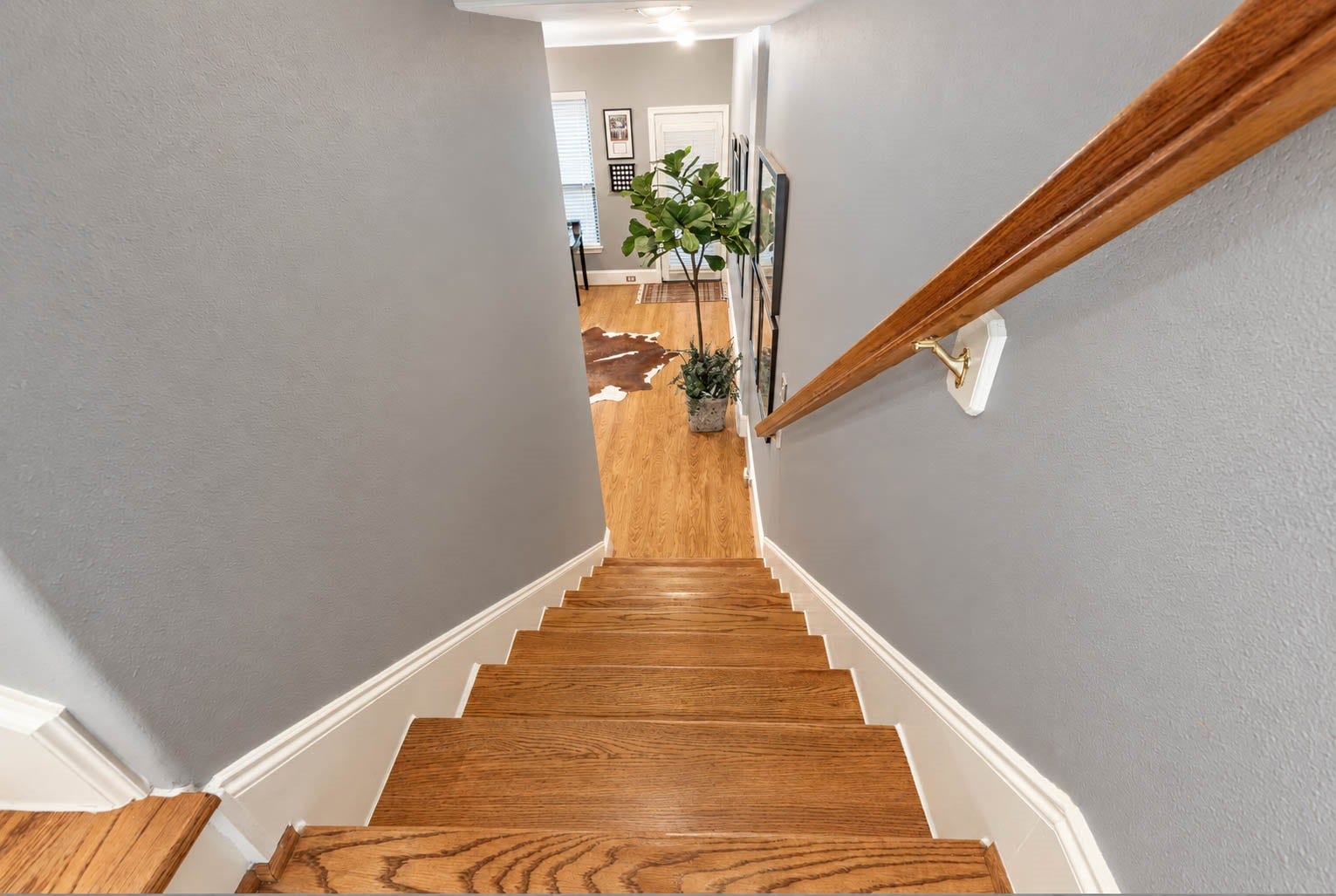 1316 Studer Street, Houston, TX 77007 Looking down the staircase offers a beautiful perspective of the homes split-level architecture. Warm wood steps, crisp trim, and the coordinating handrail create a seamless visual transition back to the first floor.